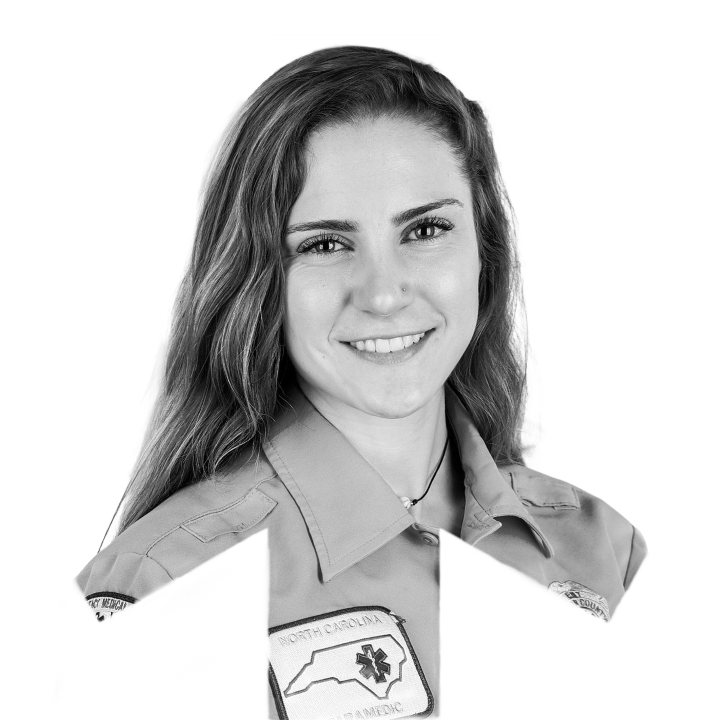 Black and white photo of a woman with long hair, wearing a shirt with a badge that says North Carolina. She is smiling and looking at the camera.