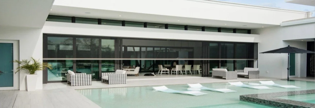 Modern house with a swimming pool, outdoor seating, and an umbrella.