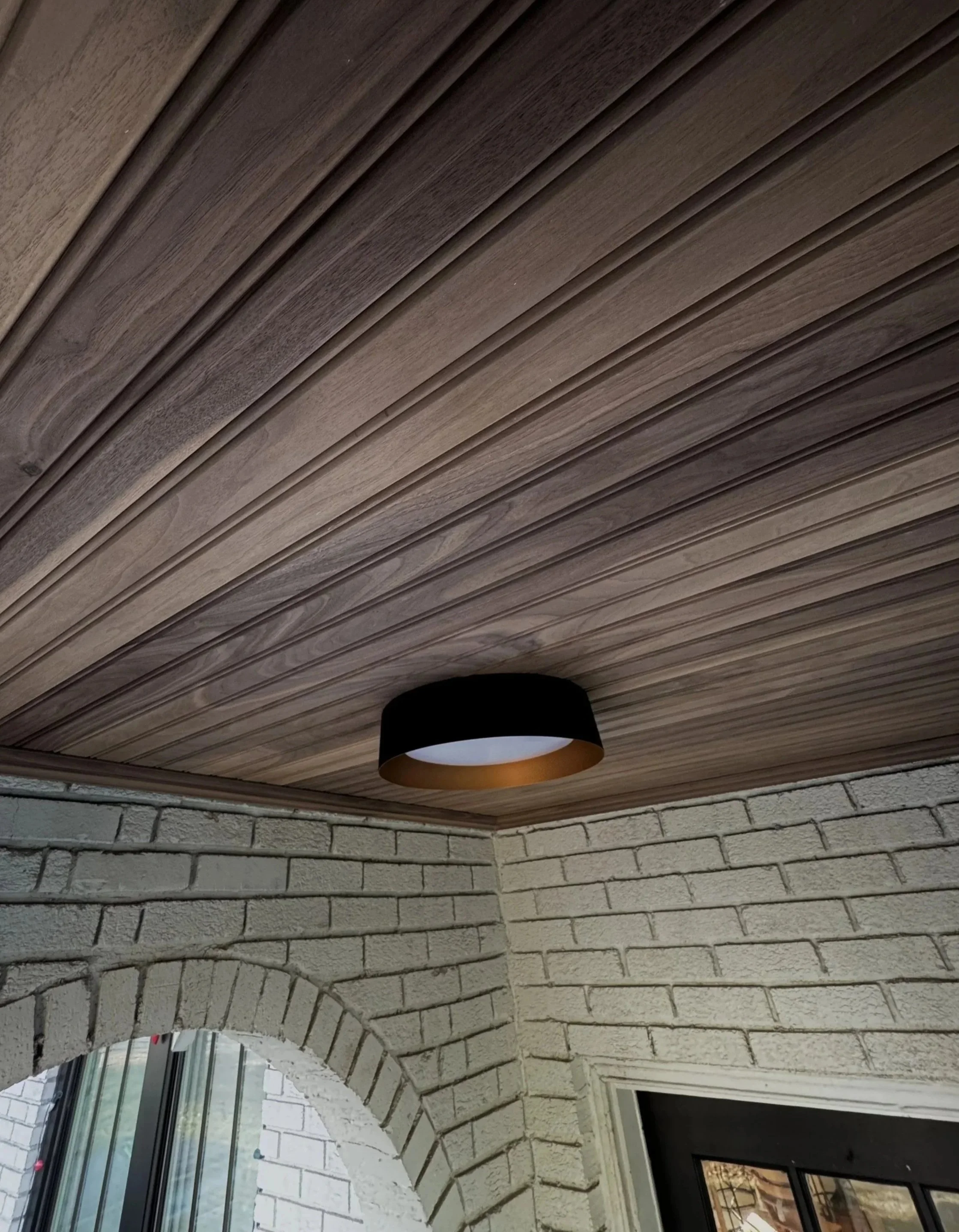 A walnut bead board ceiling adds an elegant look to arched entryway.