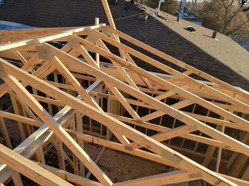 Trusses stacked over a shingled roof