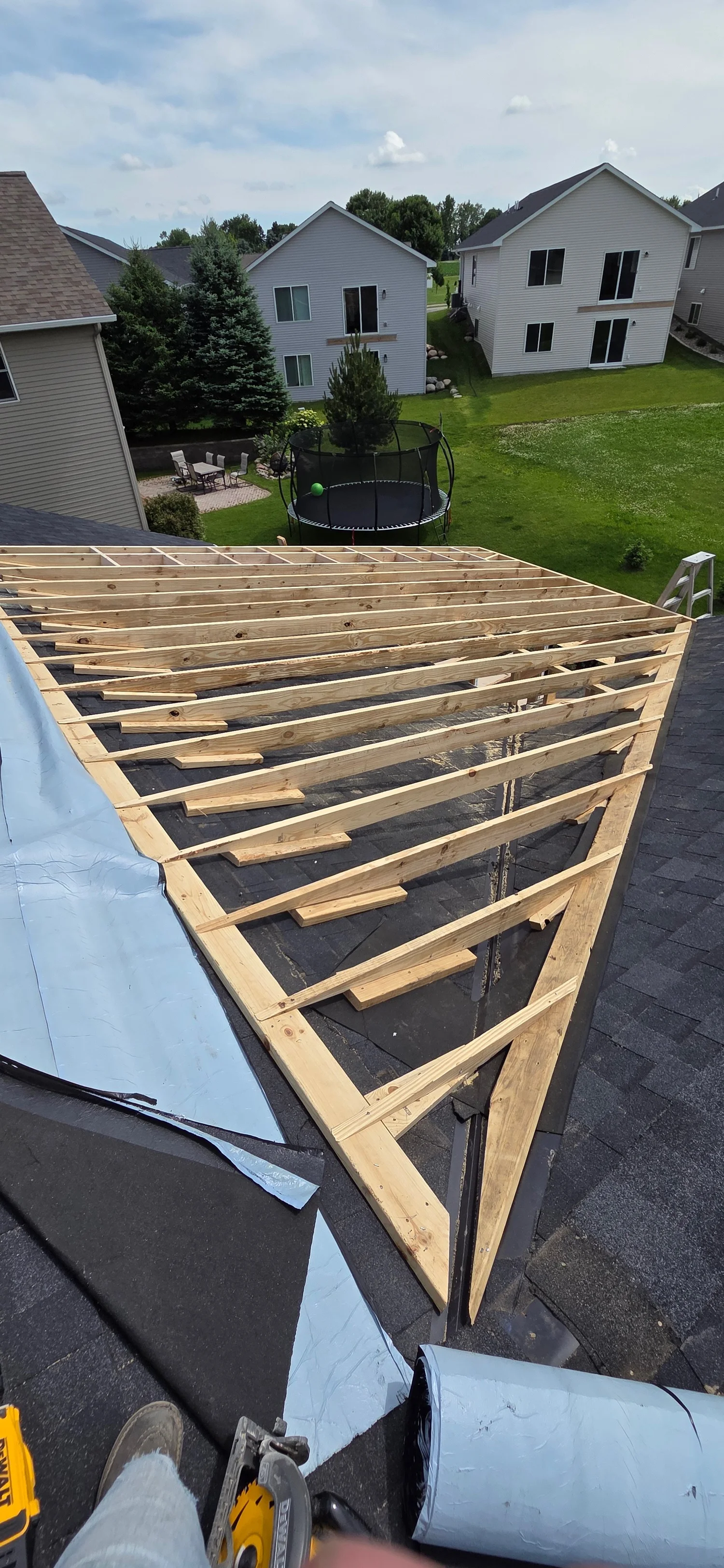 Roof framing beside finished houses