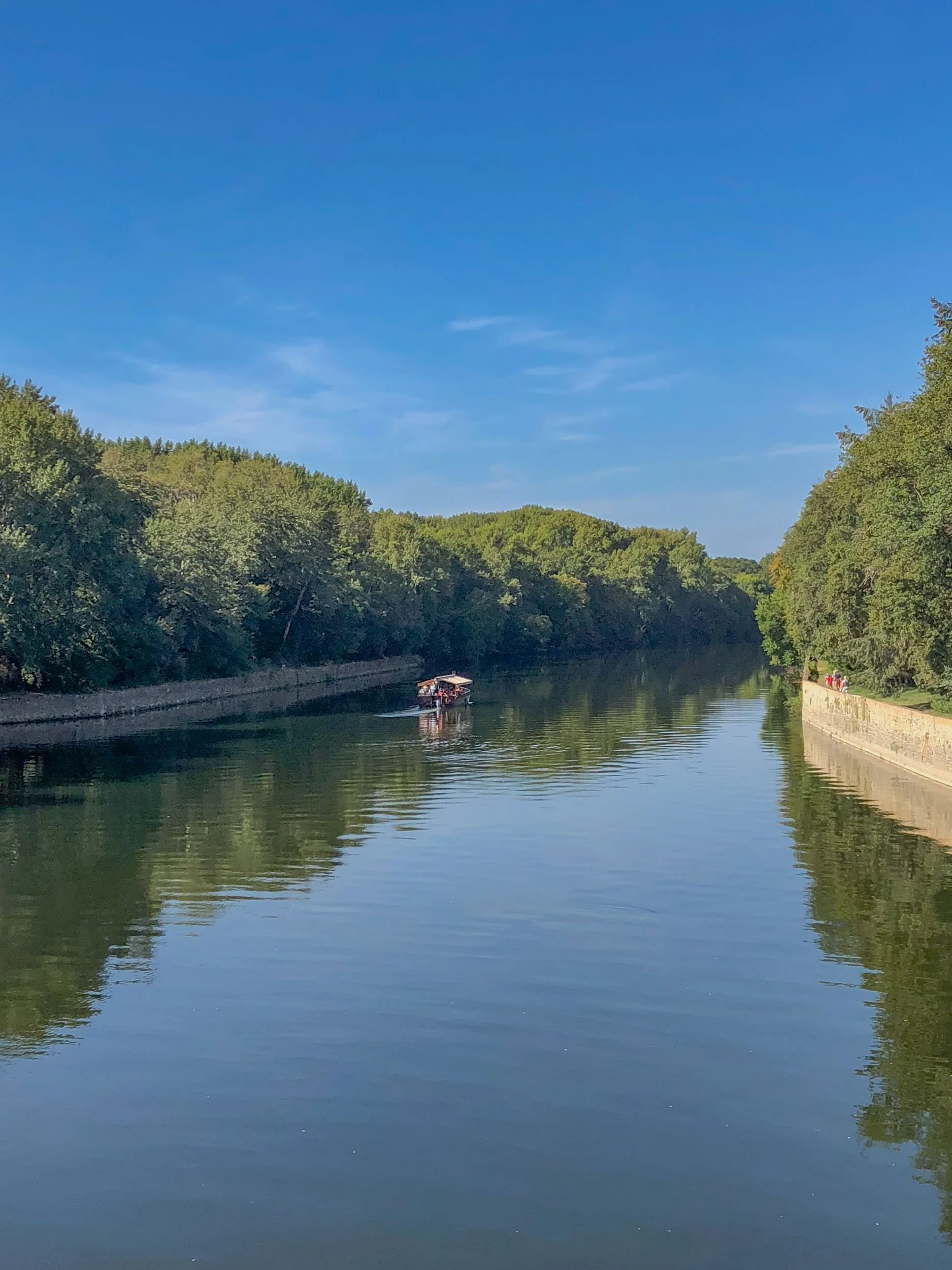 A boat lazily navigates the River Cher in France just below the Château de Chenonceau, which is actually built across the river.