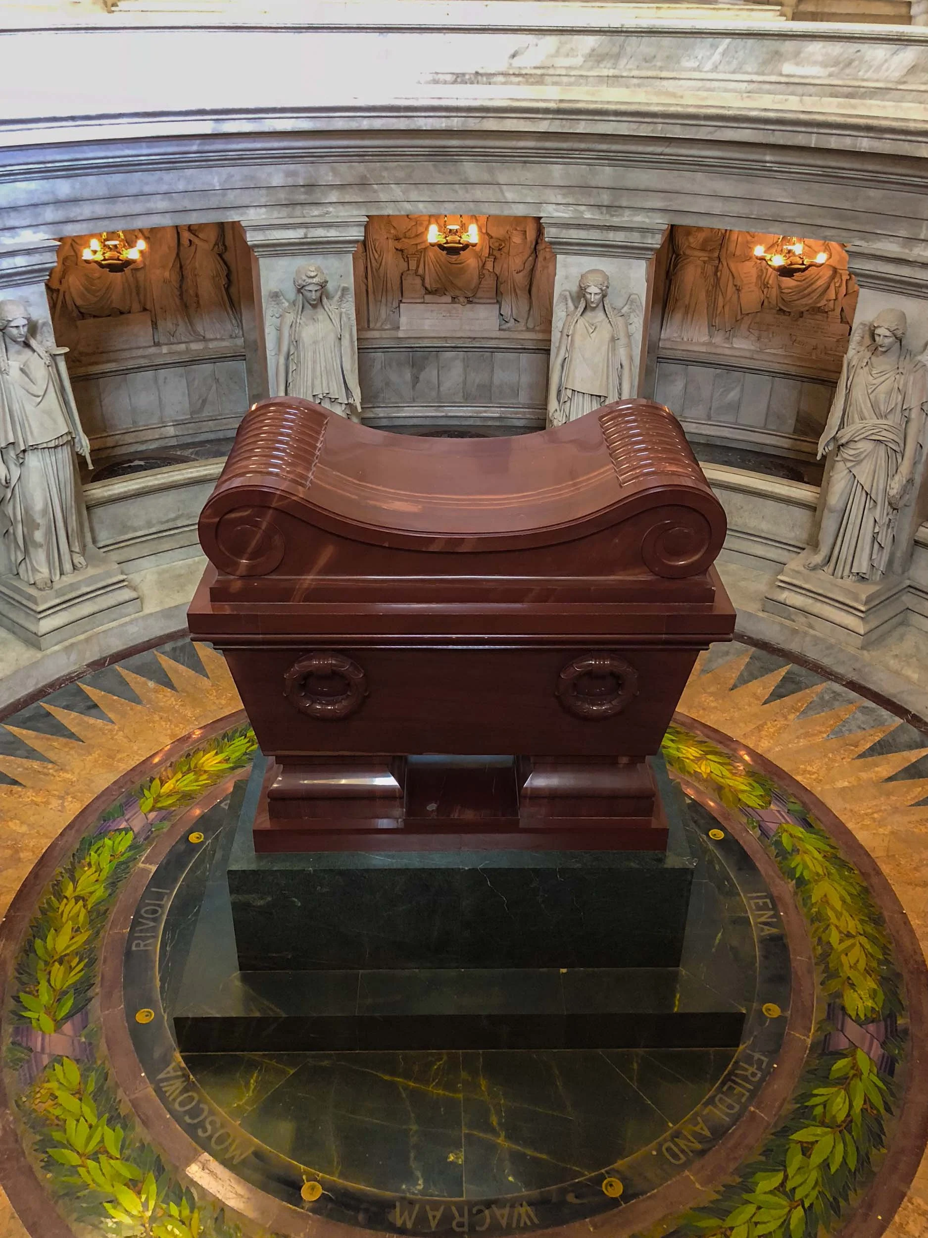 Napoleon's sarcophagus is carved from rare Russian quartzite and contains a nest of six protective coffins. Twelve colossal, toga-draped victory statues representing Napoleon's major military campaigns stand sentinel. The stone floor features a mosai