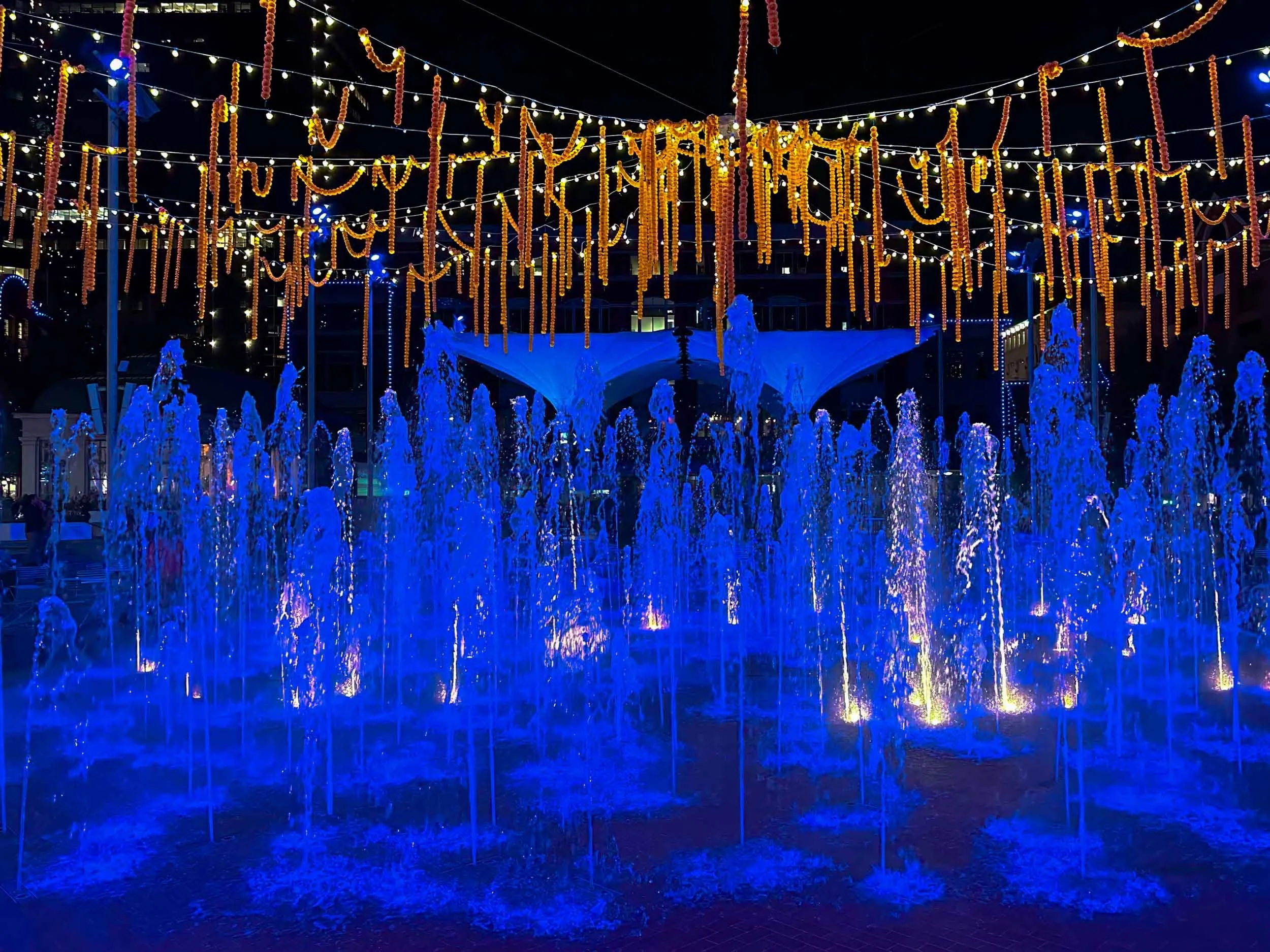 Fountain in Sundance Square (Ft. Worth) with  Halloween streamers hung overhead.