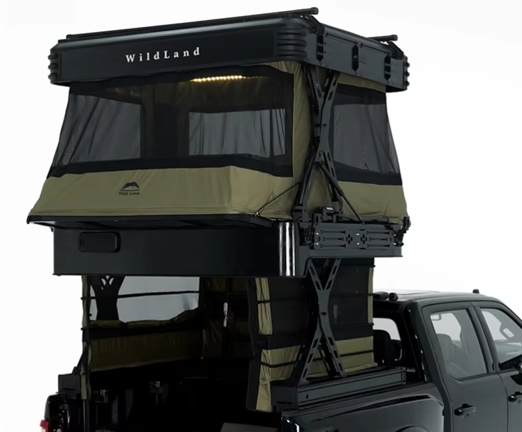 A black pickup truck with a mounted rooftop tent labeled "Wildland" in tan and black, set up for camping.