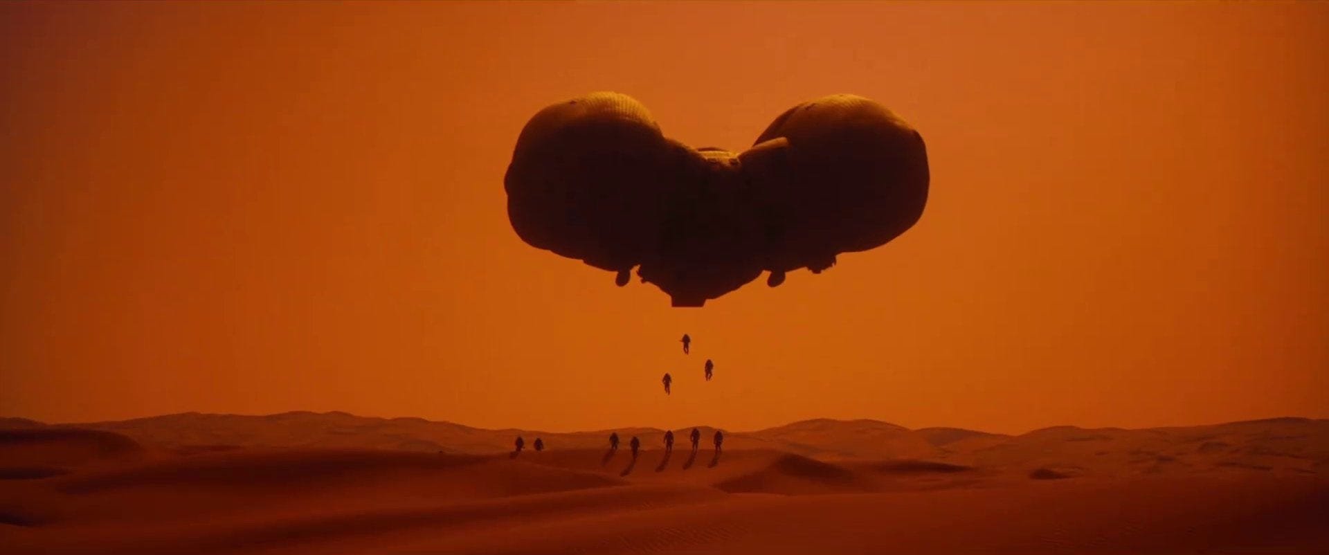 Silhouettes of astronauts descending from a large, dark spacecraft floating above a desert landscape at sunset.