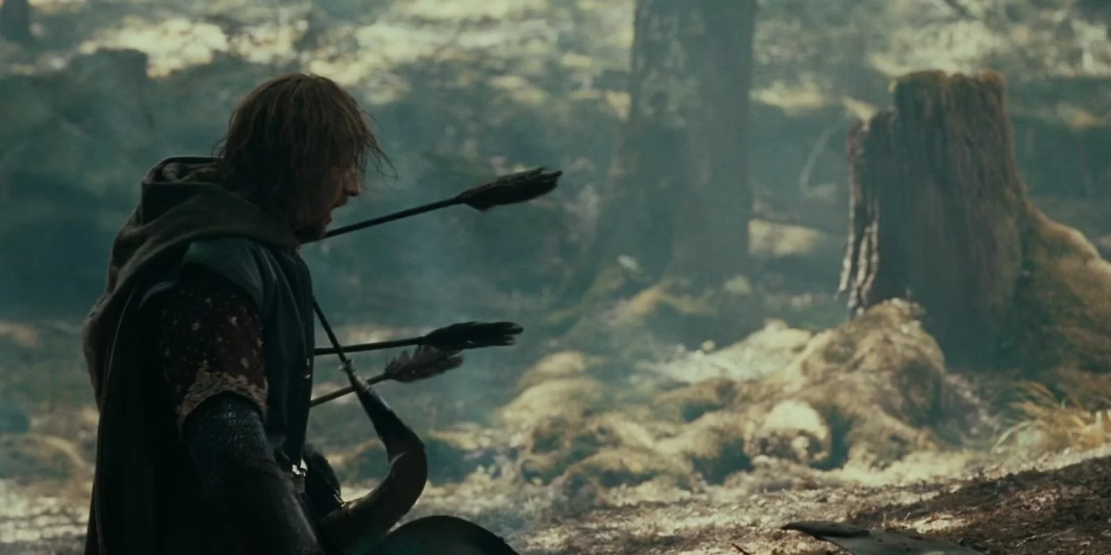 A man with disheveled hair, wearing dark clothing, sitting on the ground in a forest clearing with trees and stumps visible, holding a bow with arrows.