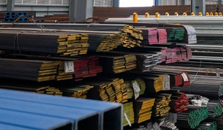 Stacks of various metal pipes and tubes stored in a warehouse.