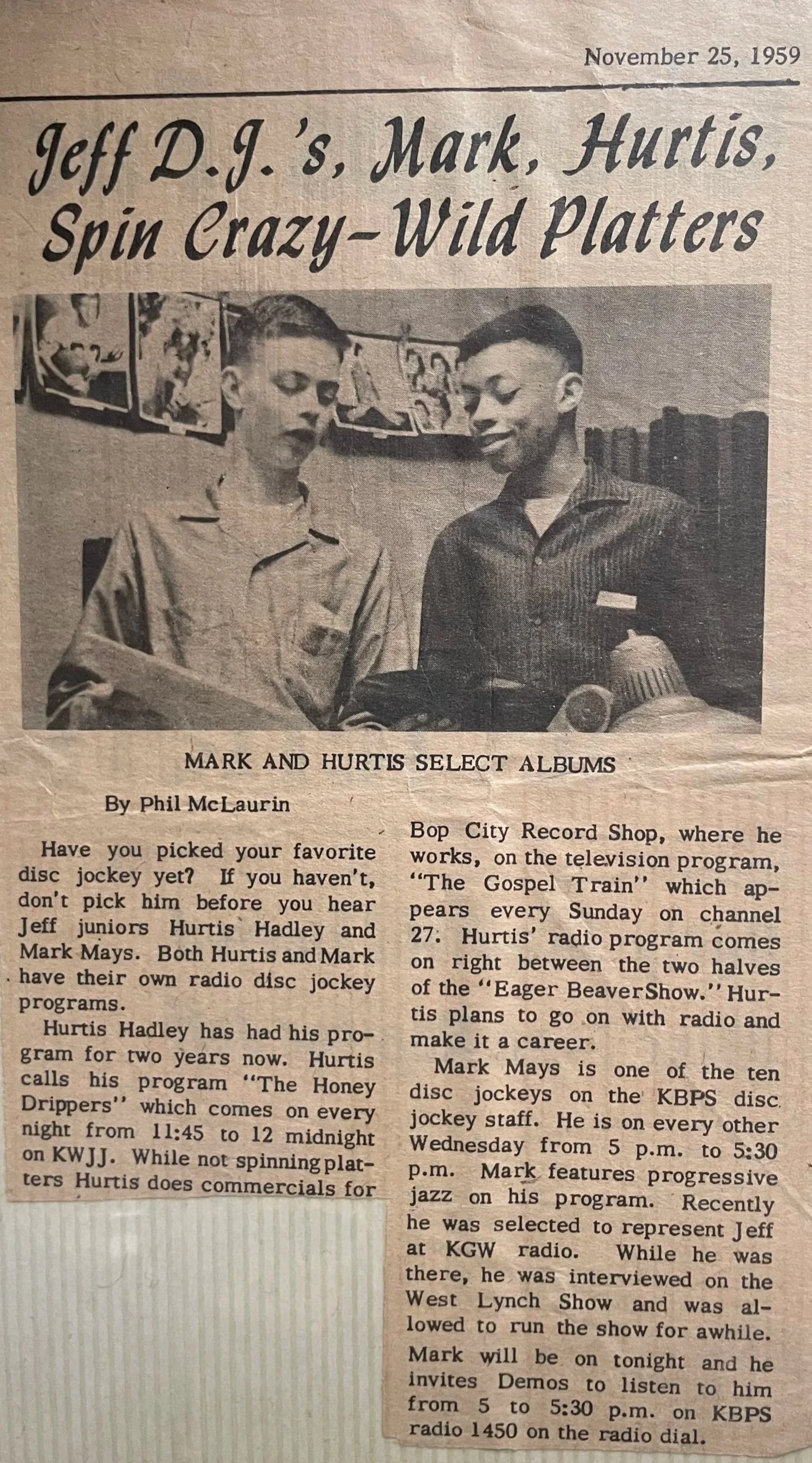 Newspaper clipping with black text. Black and white photograph at the top of the article that displays a young Hurtis Hadley standing with another young boy as they look at records. 