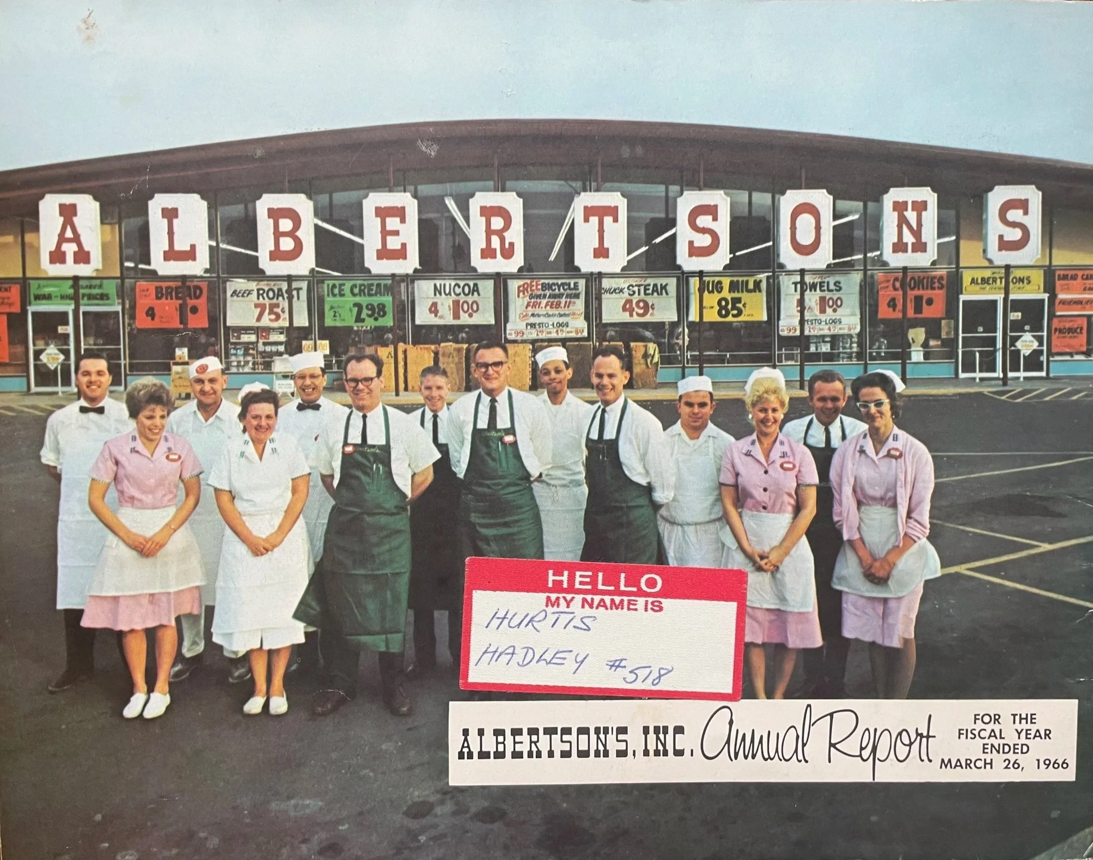 Photograph taken outside of Portland Albertsons store. Line of employees standing in front of the store. Women are wearing pink or white dresses with aprons, and men are wearing chef whites with green or white aprons. 