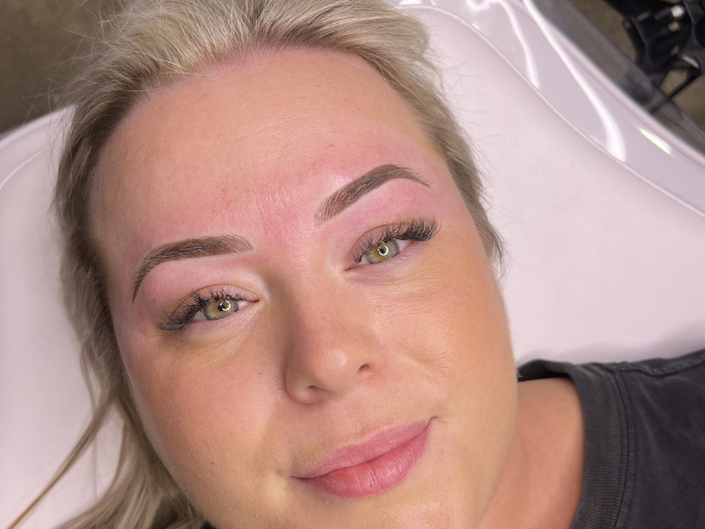 Lady looking at camera after getting cosmetic brow tattoo by banksia and blade