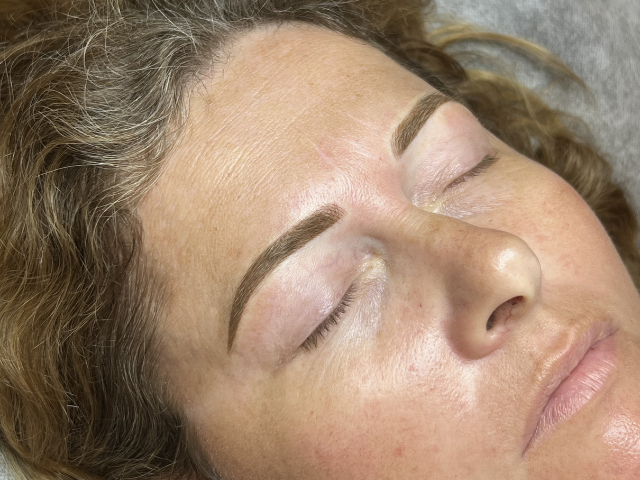 Close image of ladies face with eyes closed after cosmetic brow tattoo by banksia and blade in melbourne
