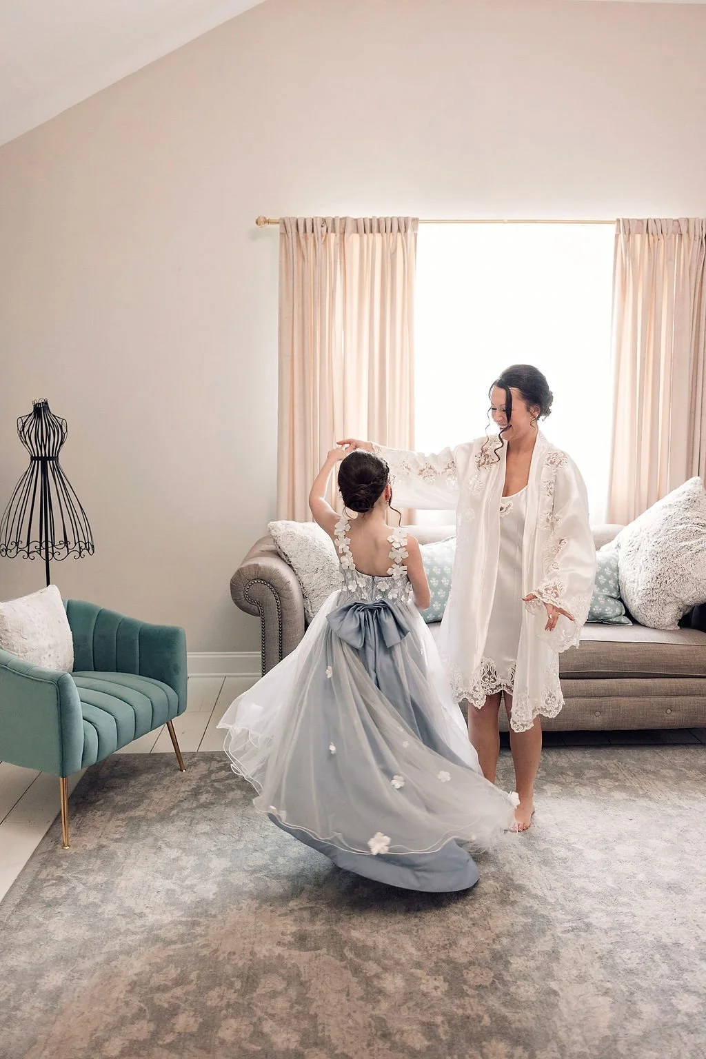Bride twirls flower girl in light blue dress in Ramble Creek luxury bridal suite in Athens, TN