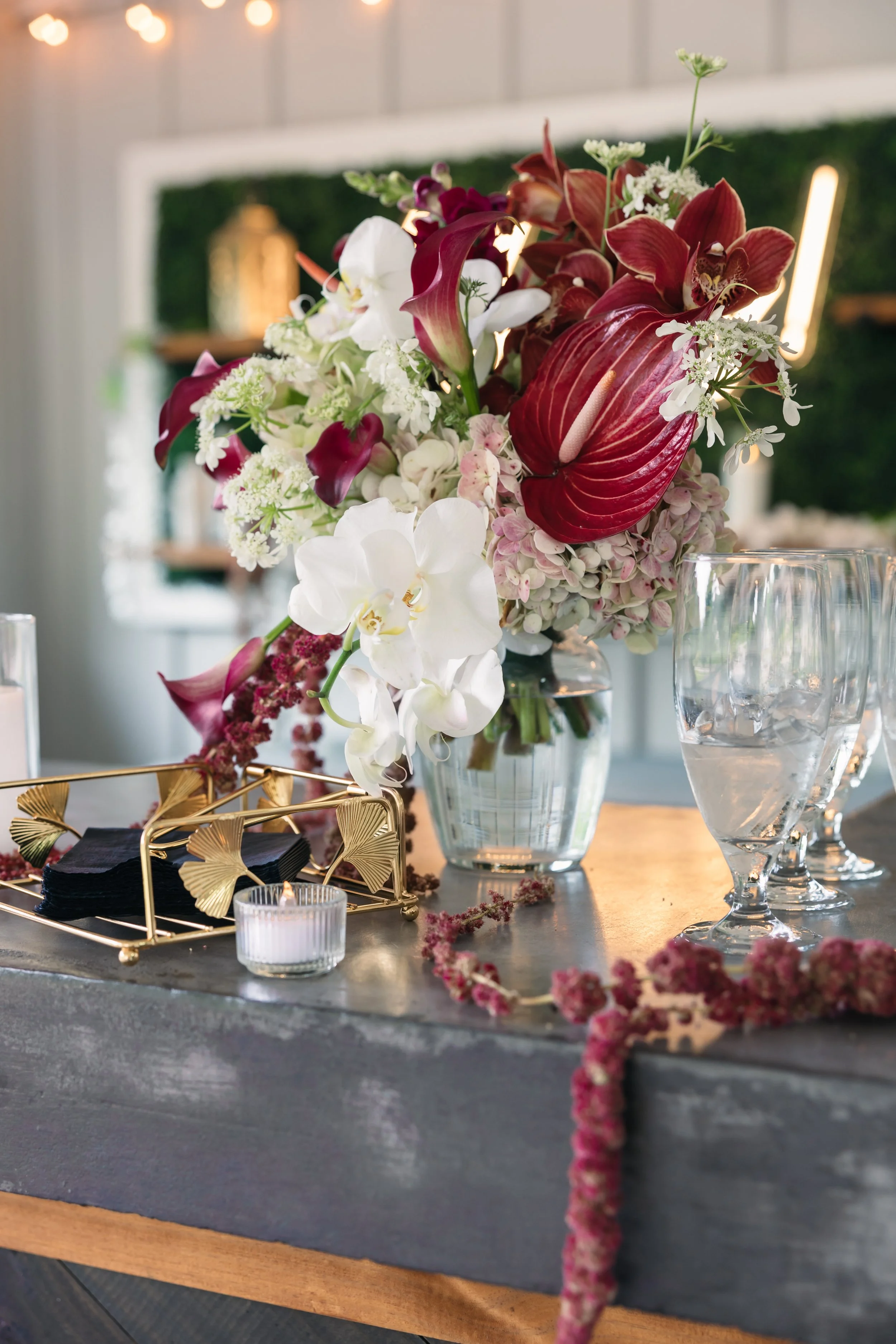 Ramble Creek wedding cocktail hour arrangement on bar with water glasses