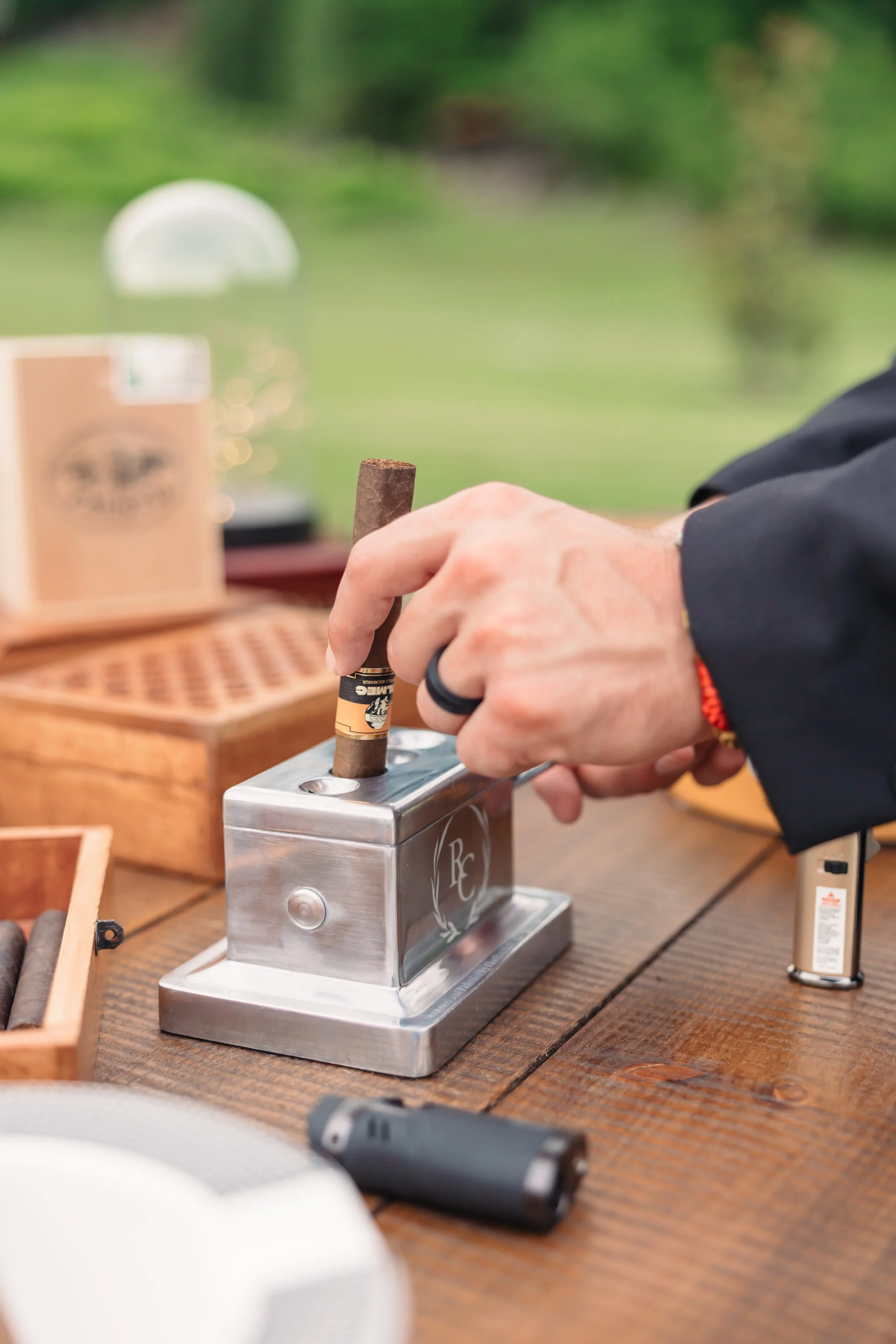 A close-up stock image featuring a cigar and glass of whiskey on a dark tabletop, creating a sophisticated and relaxed cigar bar atmosphere for wedding reception