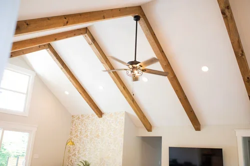 Vaulted ceiling inside the Villa at Ramble Creek, featuring exposed wood beams, a ceiling fan, recessed lighting, and bright natural light.