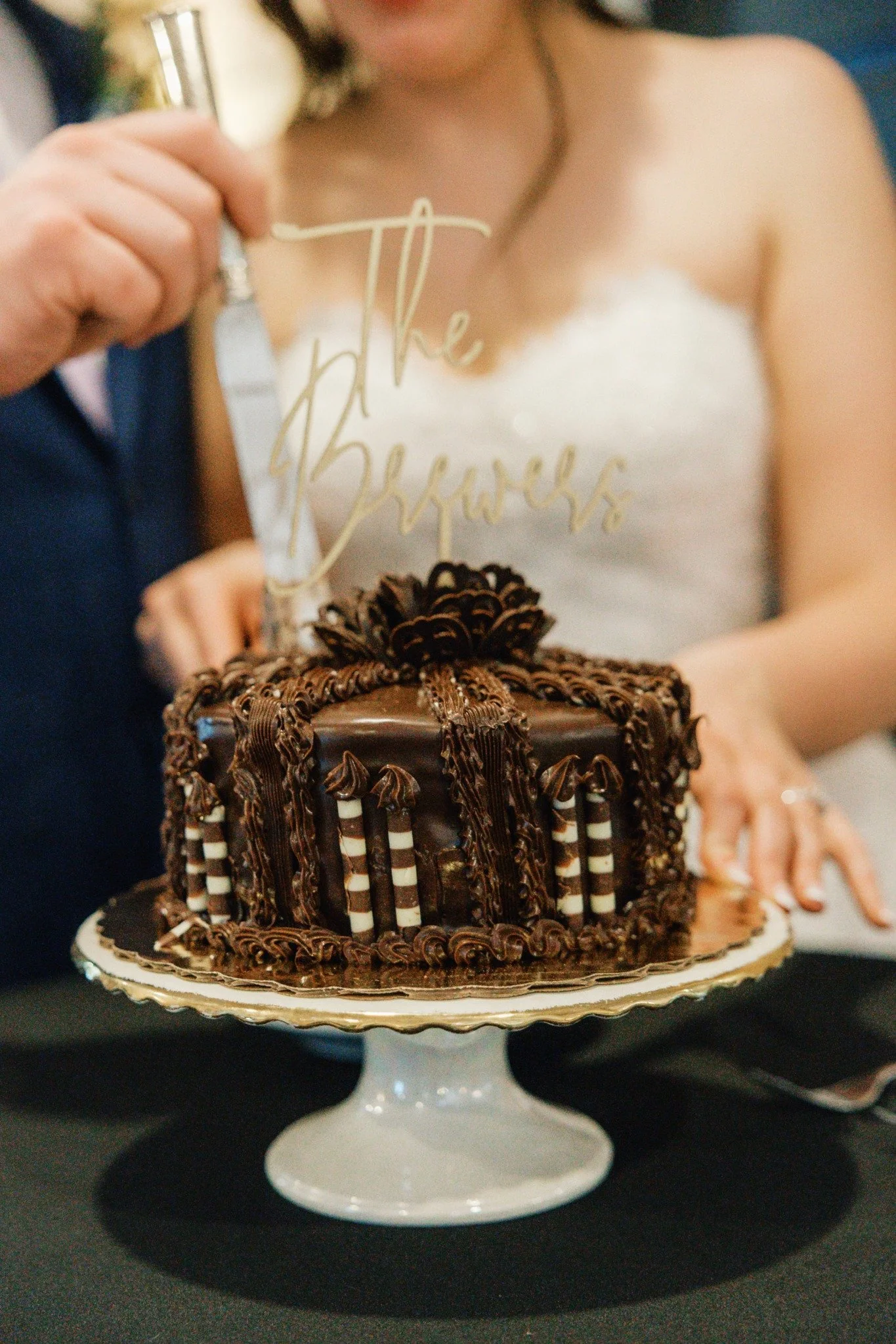 Couple cutting a chocolate wedding cake during their reception at Ramble Creek wedding venue in Tennessee.