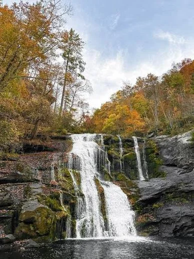 Bald River Falls cascades over moss-covered rock near Tellico Plains, TN, with roadside views for photos and a nearby trail for hiking.