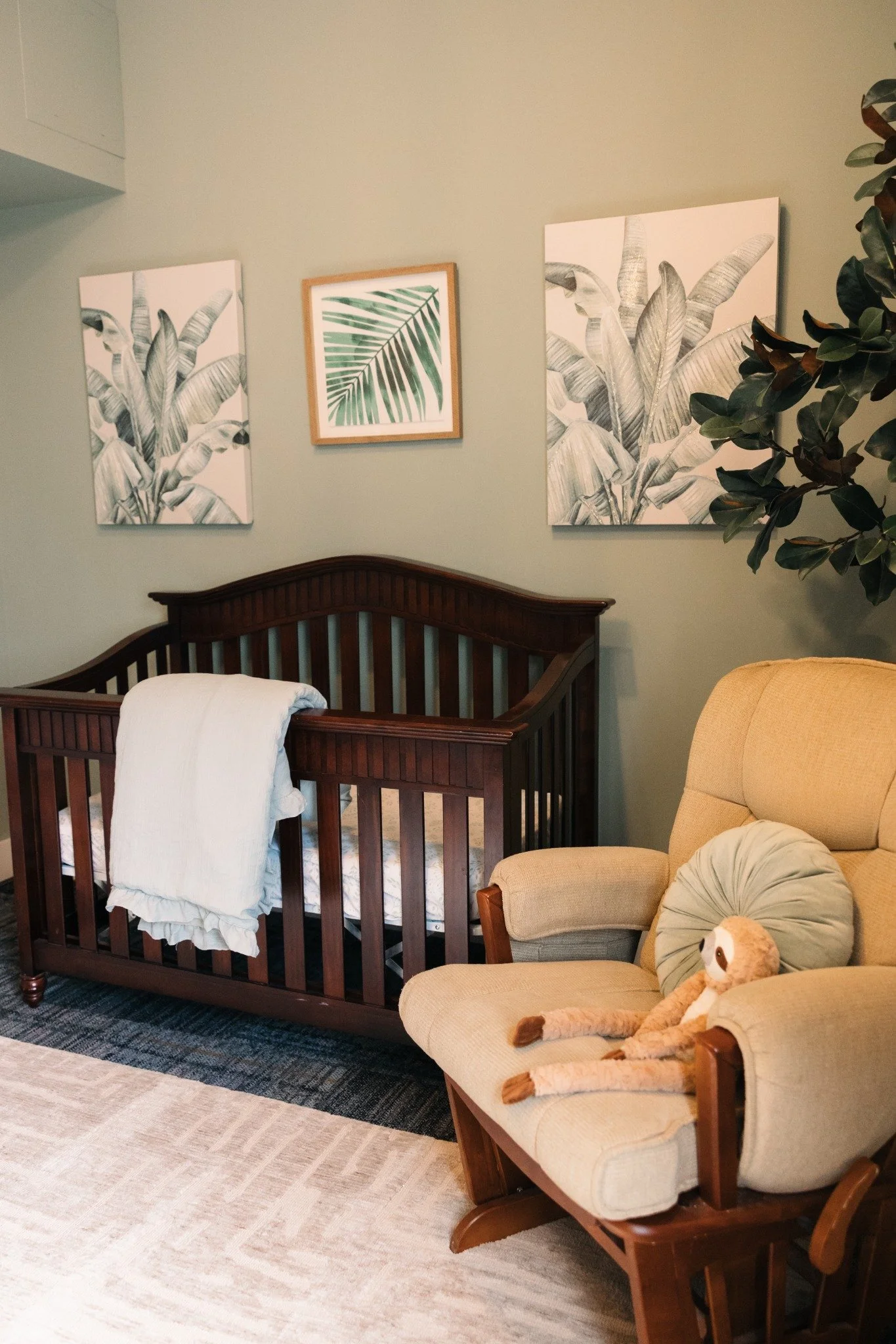 Ramble Creek nursery with crib, rocking chair, botanical art, and soft seating for families during wedding celebrations.