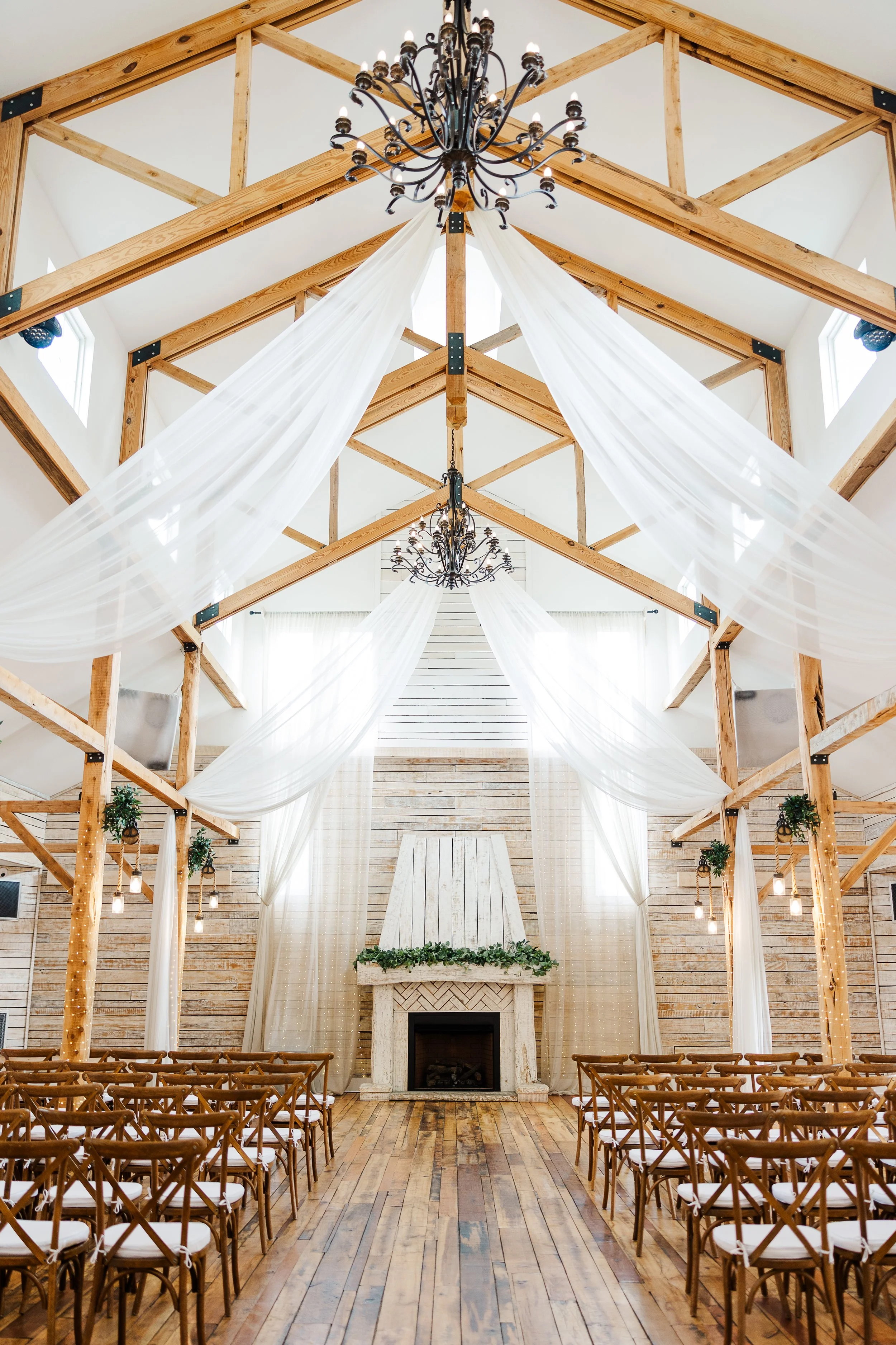 Wedding cake table at Ramble Creek featuring elegant green draping, lace linens, candlelight, and soft blush and ivory floral arrangements.