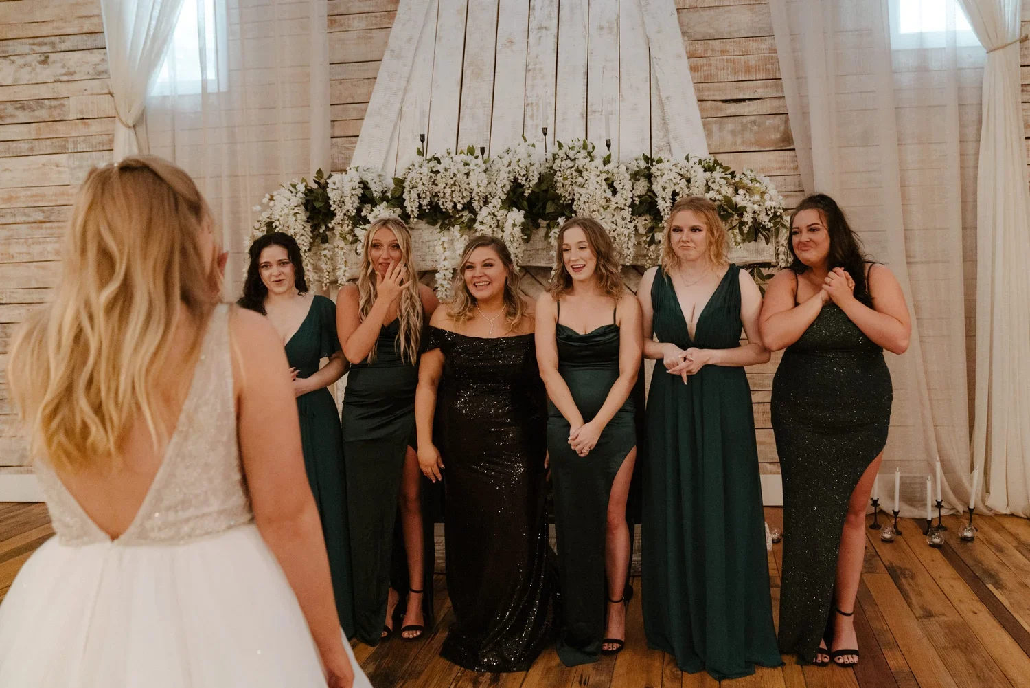 Bride’s first look with bridesmaids in emerald green and black sequin dresses inside the Ramble Creek wedding venue, Grand Hall