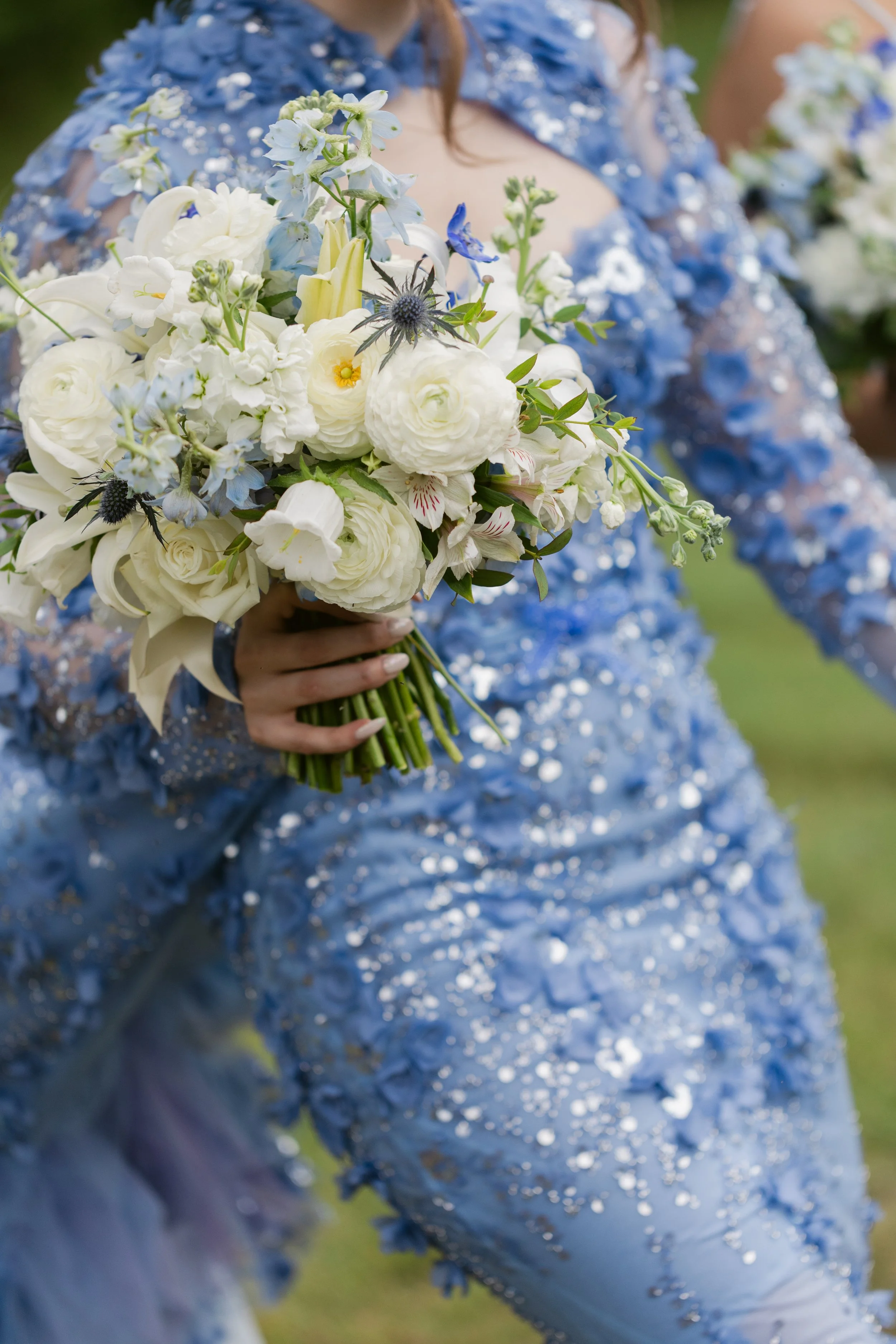 Close-up of a bride’s white and blue bouquet with her blue floral wedding dress at Ramble Creek, an all-inclusive East Tennessee wedding venue in Athens TN.