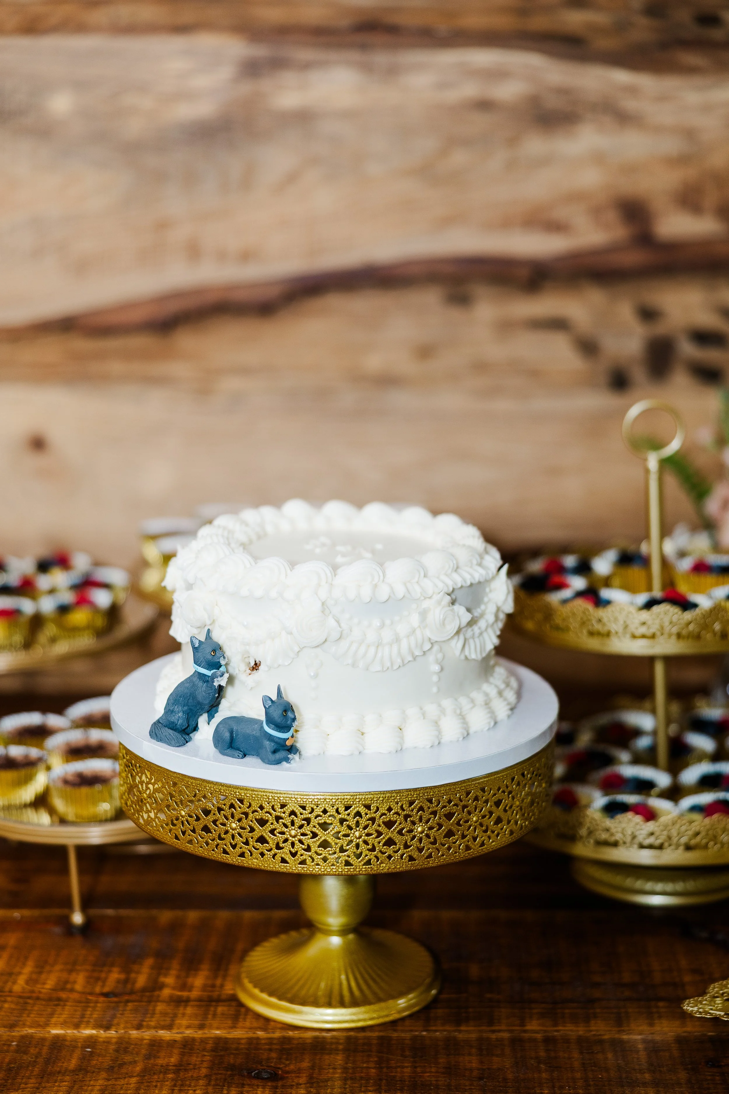 White wedding cake with custom cat cake decoration at a Ramble Creek wedding reception.