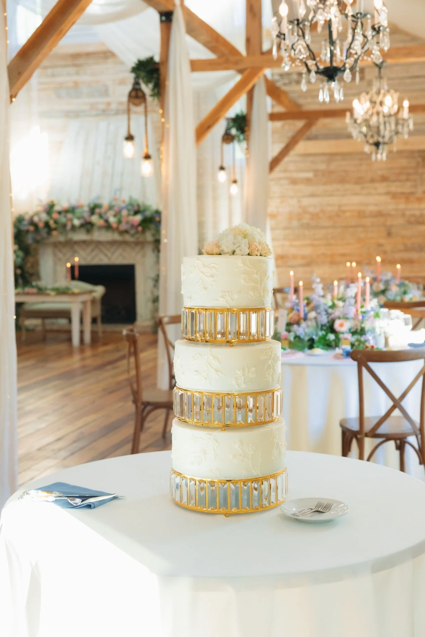Elegant tiered wedding cake with gold accents displayed inside the Ramble Creek reception space in Tennessee.