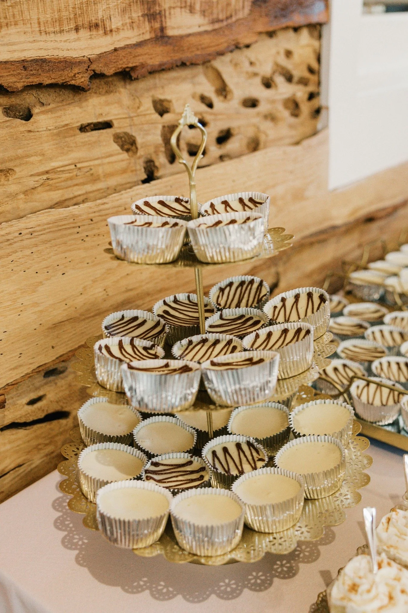 Mini cheesecakes displayed on a gold tiered dessert stand at a Ramble Creek wedding reception in Tennessee.