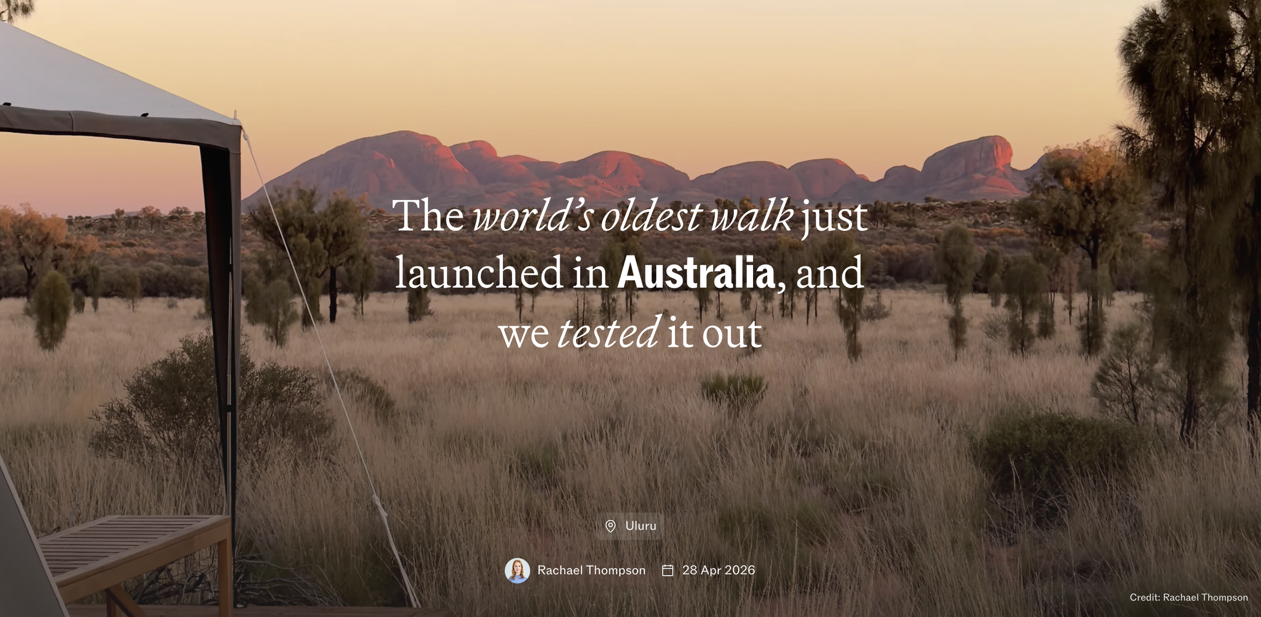 A scenic landscape of grassland with scattered trees and rocky mountains in the distance at sunset, with overlaid text about Australia's oldest walk.