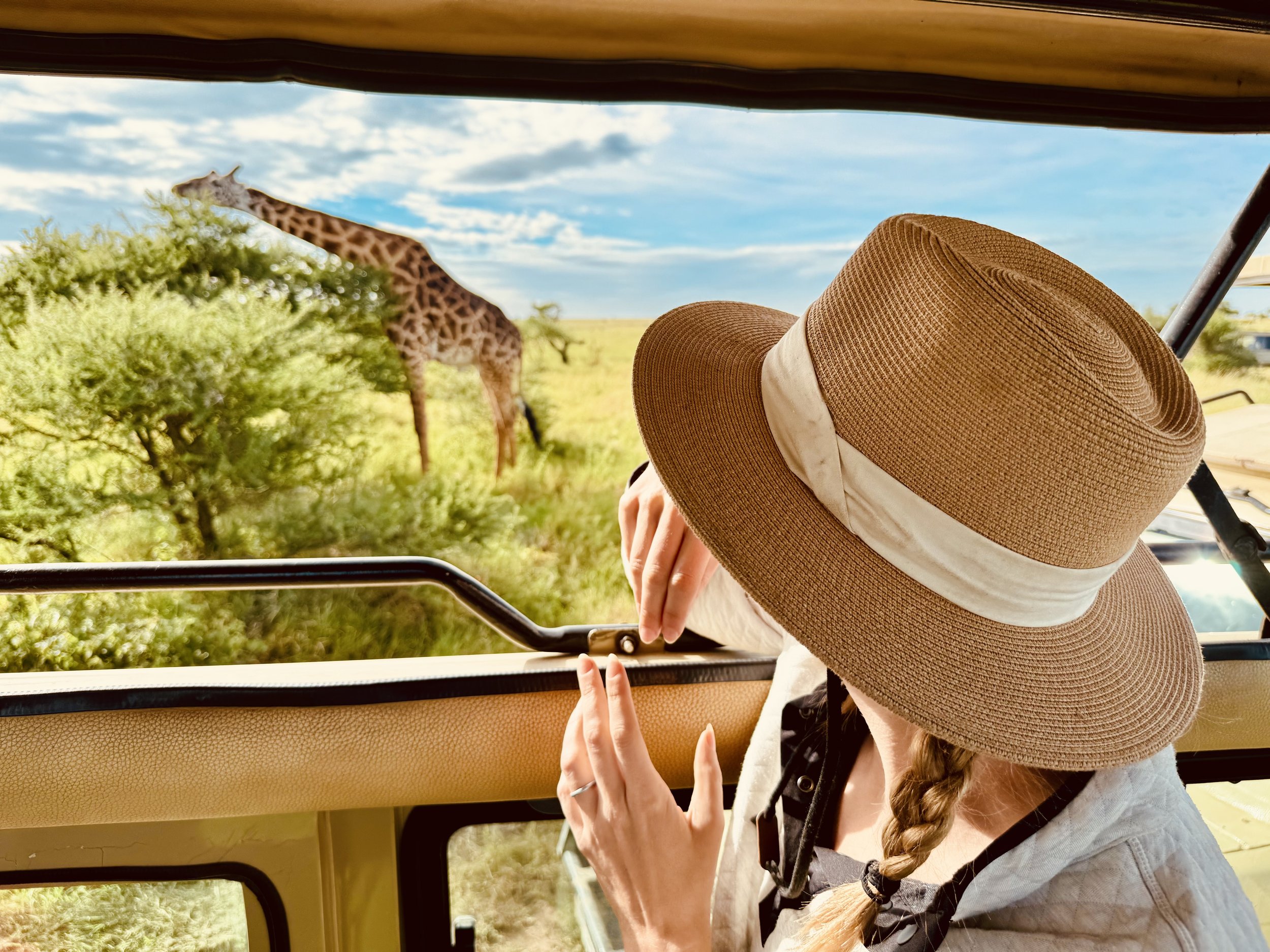 woman looking at a giraffe on a safari