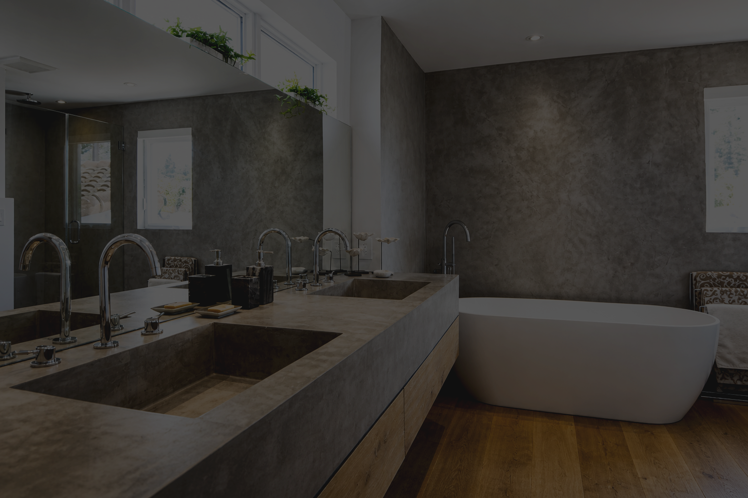 Modern bathroom with a stone countertop double sink, chrome faucets, a freestanding bathtub, a large mirror, and windows letting in natural light.