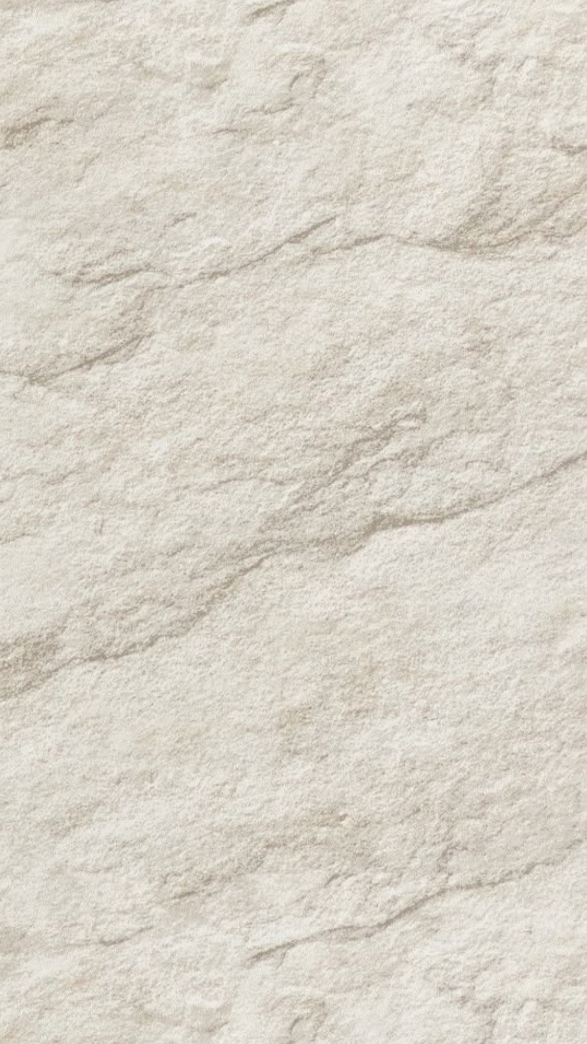 Close-up of a light-colored, textured stone or marble surface.