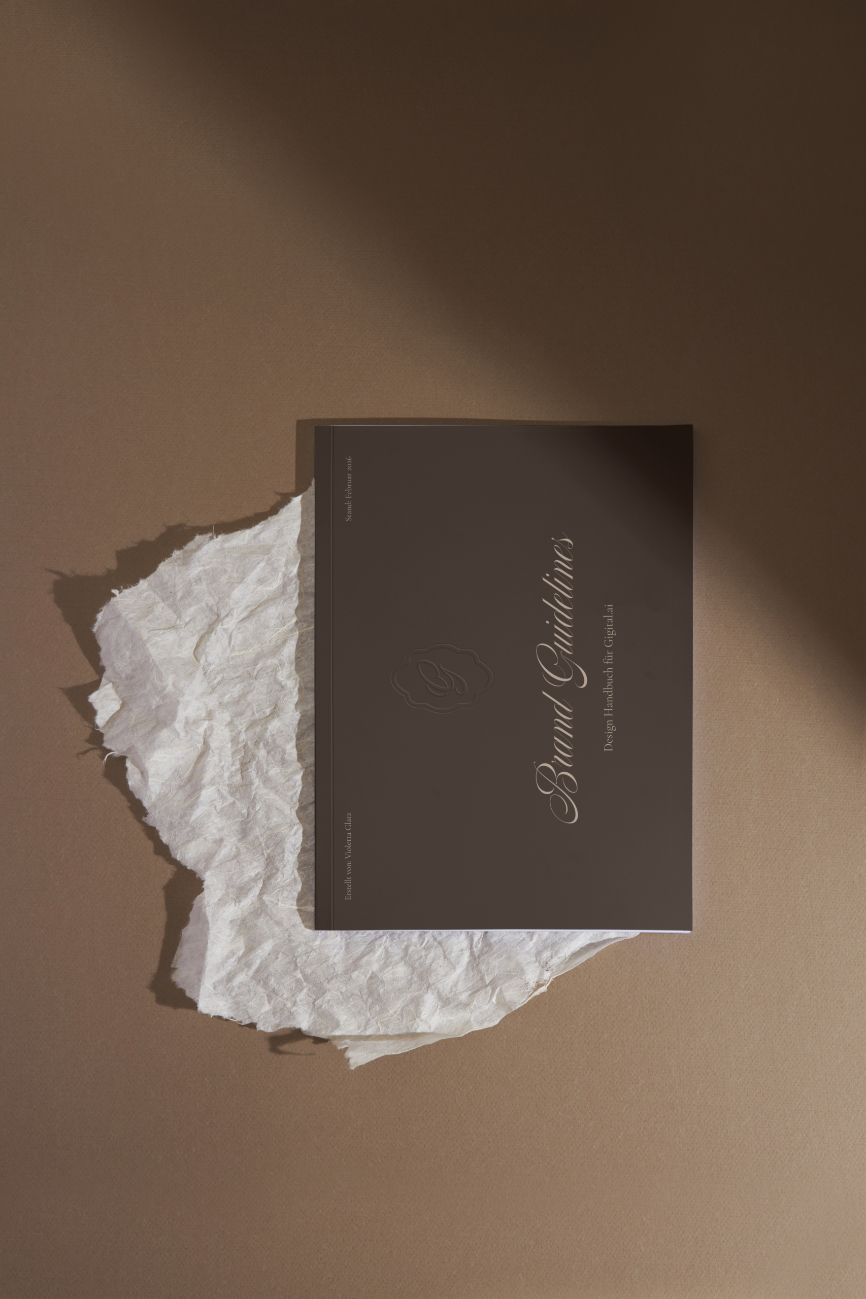 Ein schwarzes Buch mit dem Titel 'Brand Briefings' liegt auf zerknülltem Papier auf einem braunen Hintergrund.