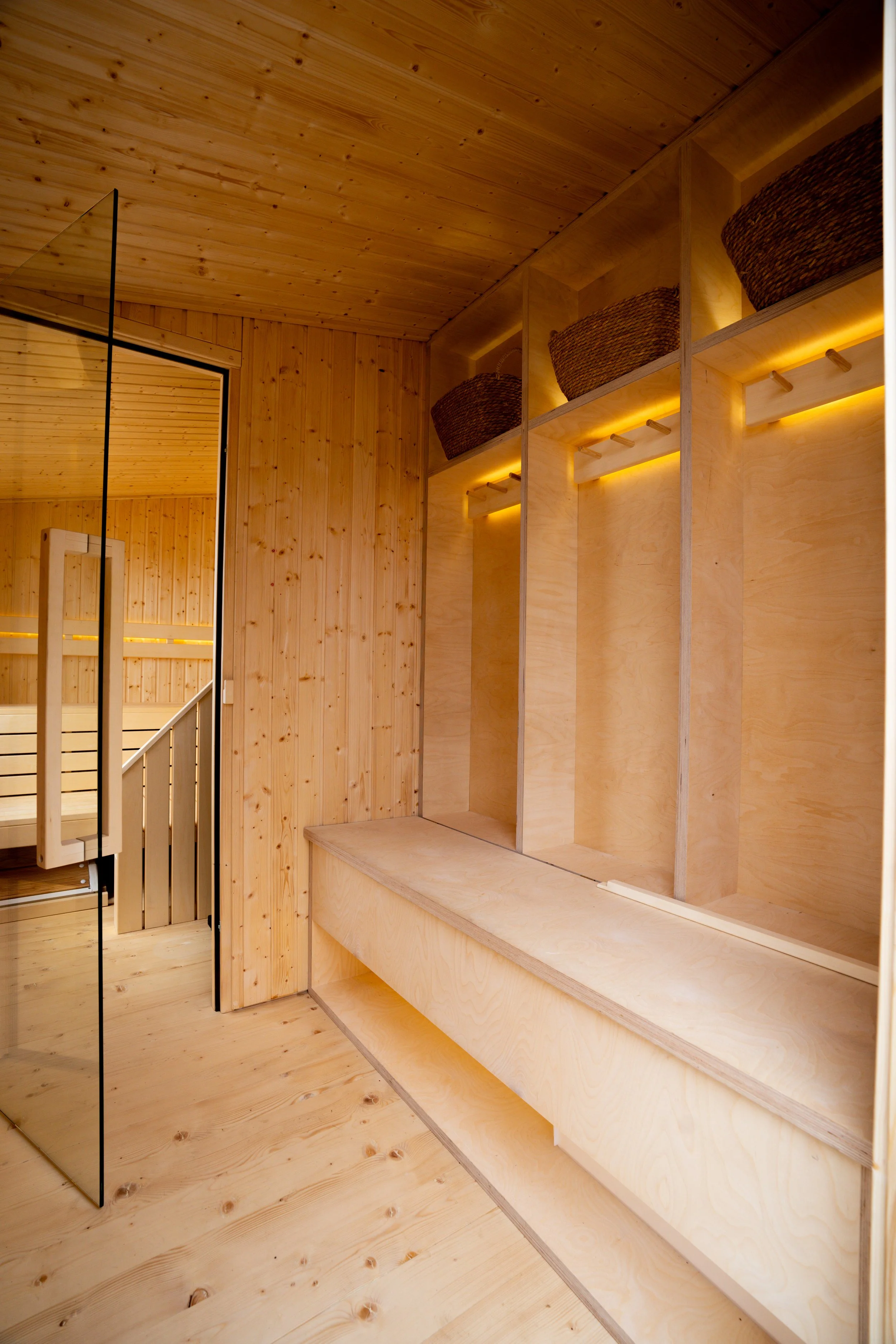 Wood-paneled interior with shelves holding woven baskets and warm lighting.