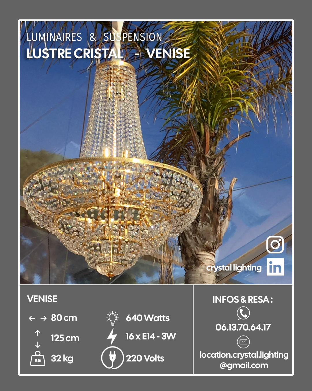Un cristal de lustre suspendu luxueux avec de nombreuses pierres scintillantes, accroché à une palme devant un ciel bleu.
