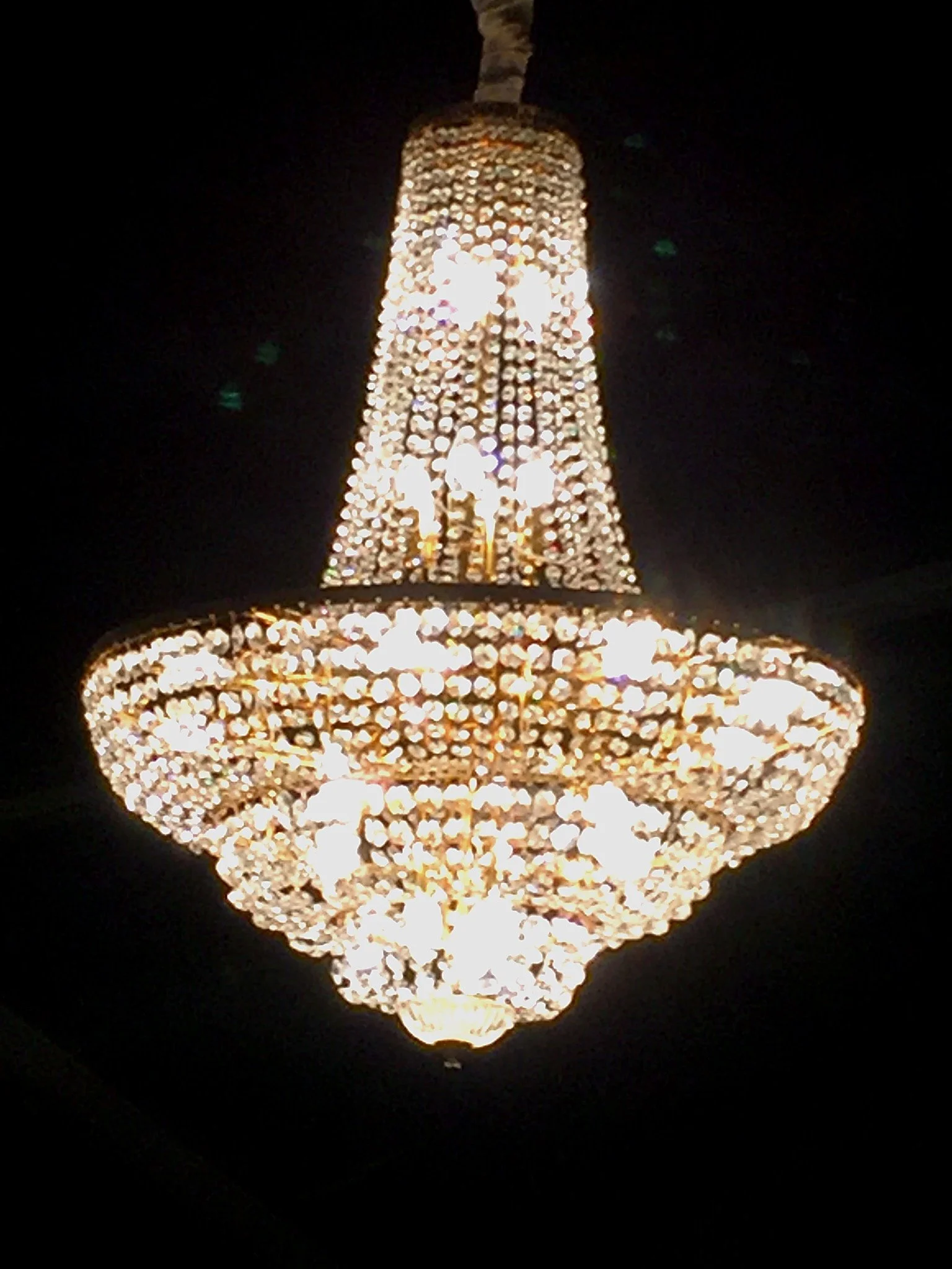 Un chandelier en cristaux brillants suspendu dans l'obscurité.