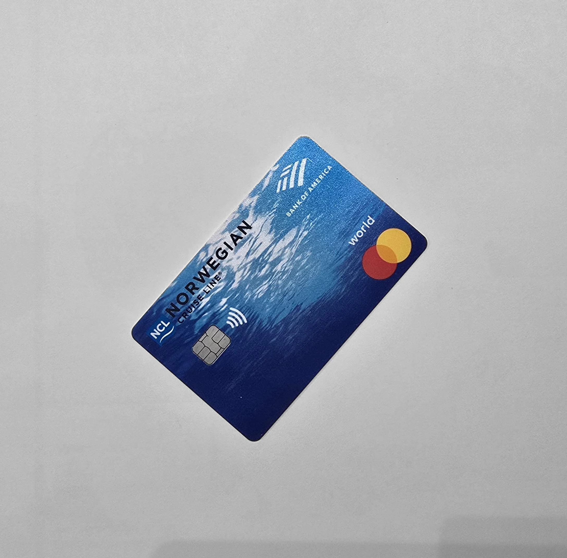 Blue MasterCard credit card partially visible, placed on a plain surface.