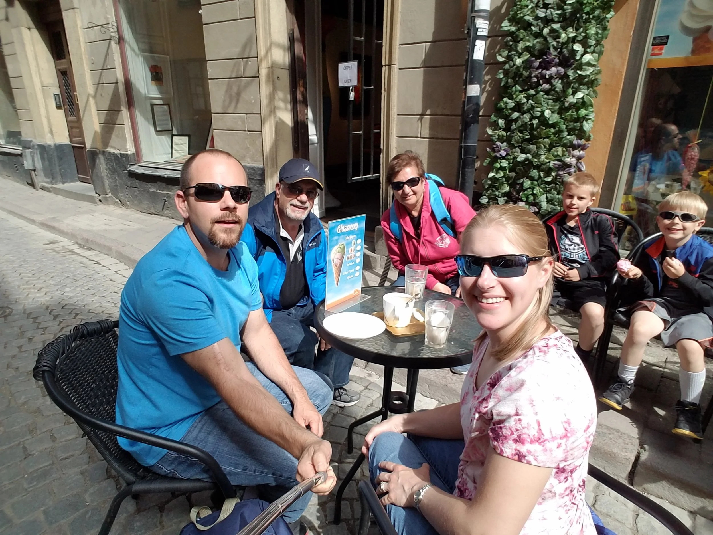Three generations of a family at an outdoor café table in Stockholm, Sweden
