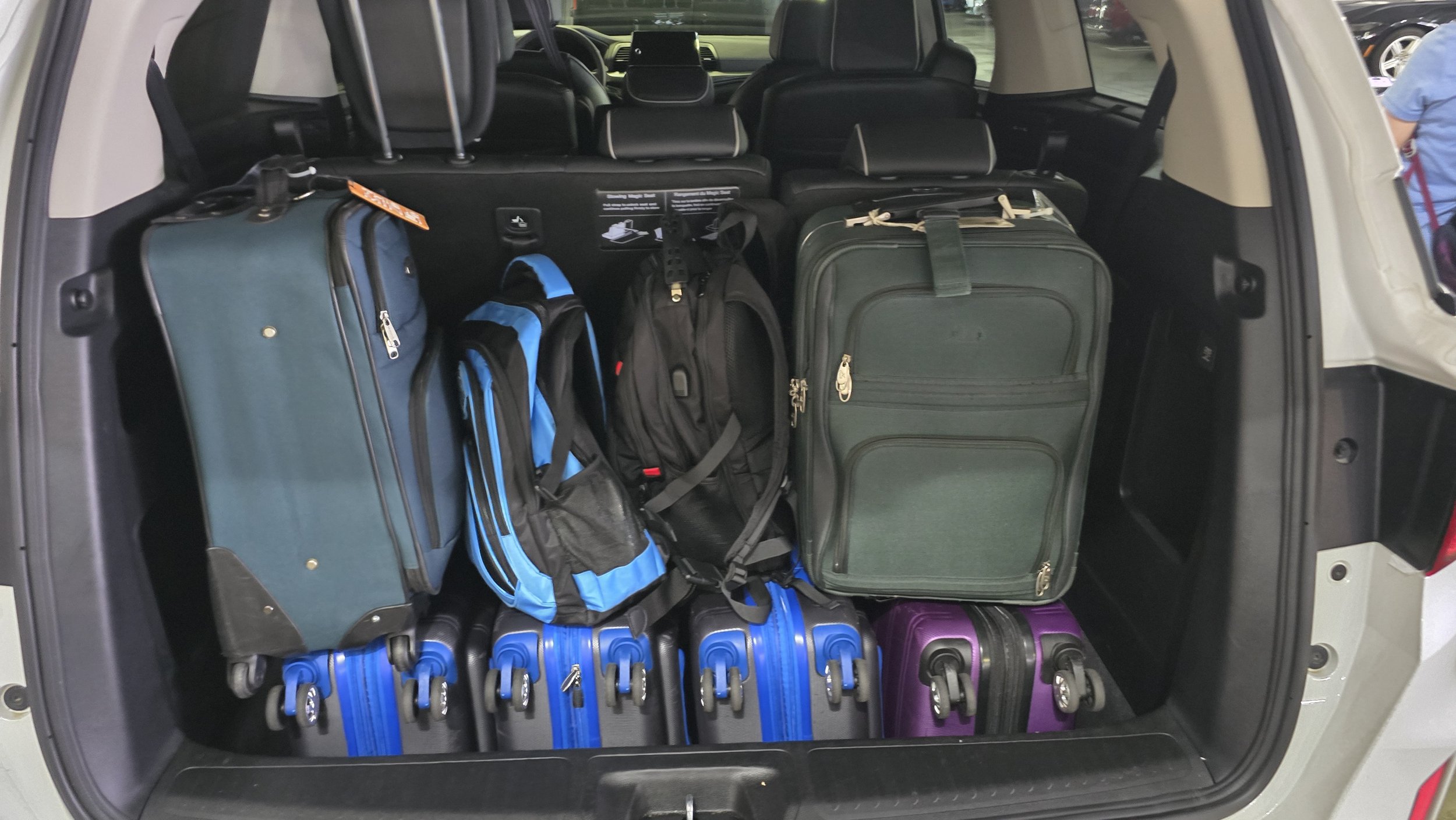 SUV trunk packed with suitcases and backpacks for a multi-generational European family trip
