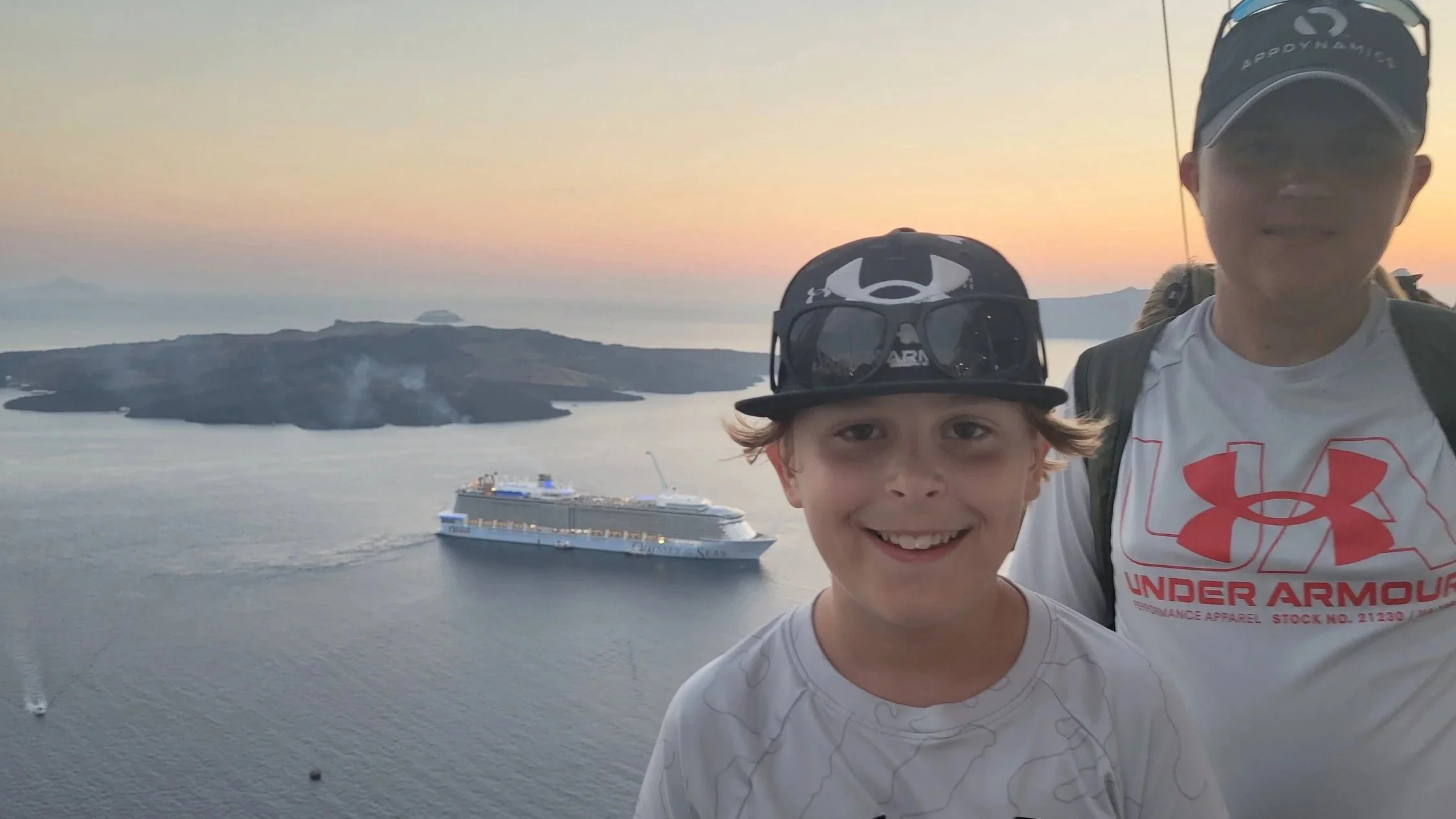 Two kids posing for the sunset with a cruise ship below in the Mediterranean Sea