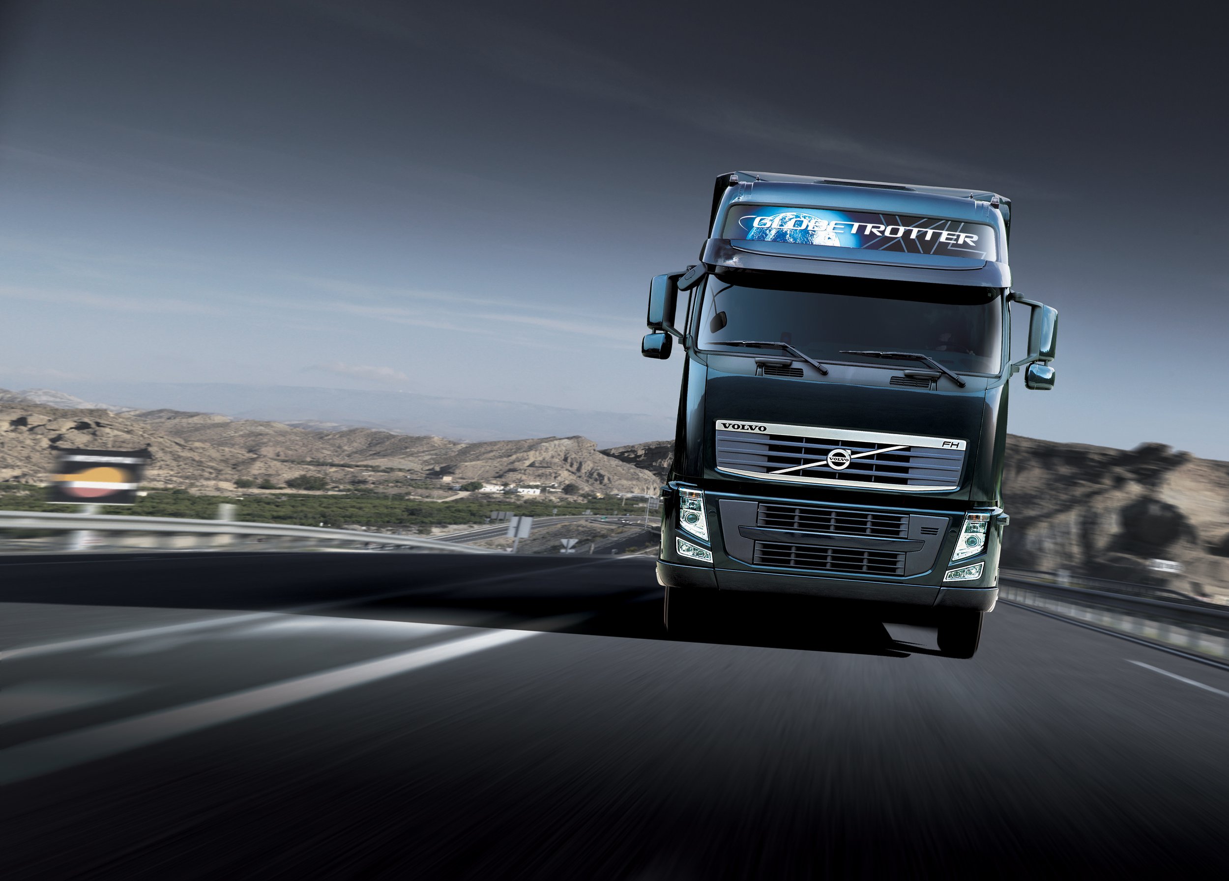 volvo-fh-globetrotter-leaflet-driving-front-mountain-dark-green-01.jpg