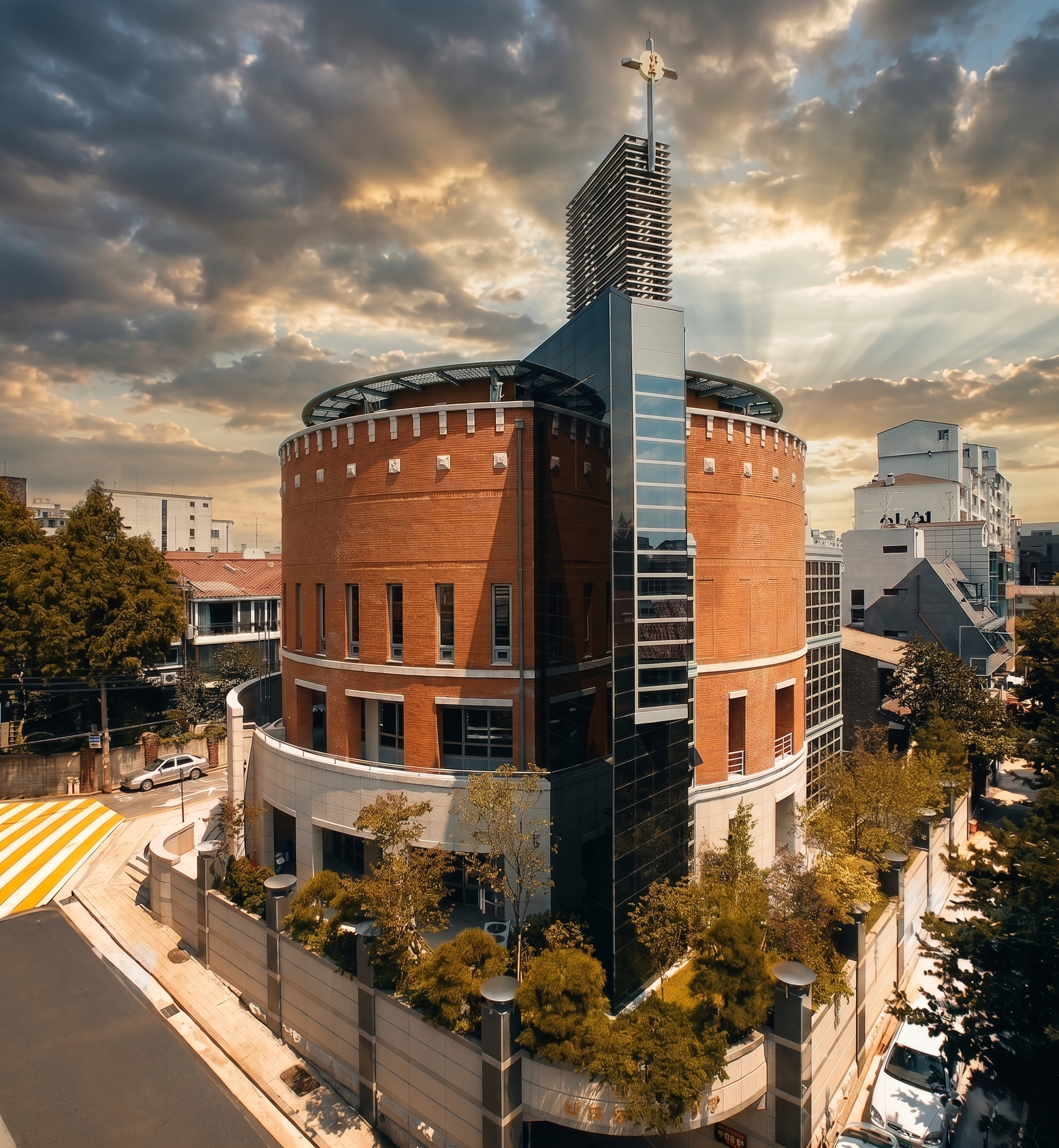 apgujeong-catholic-church-exterior-round-brick-tower-cross-aerial-sunset-01.png