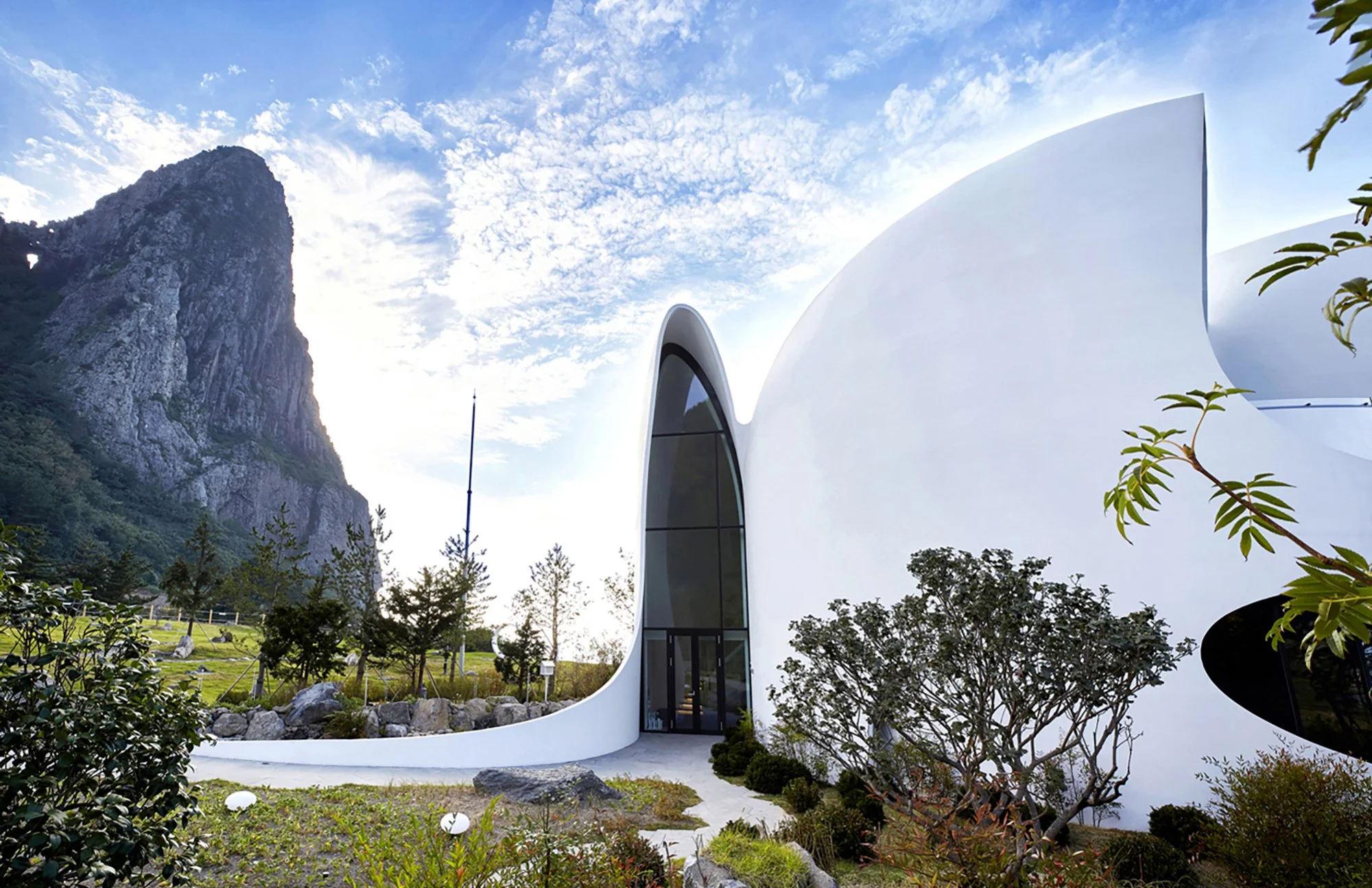 ulleungdo-organic-architecture-chapel-exterior-three-quarter-white-rock-mountain-01.jpg
