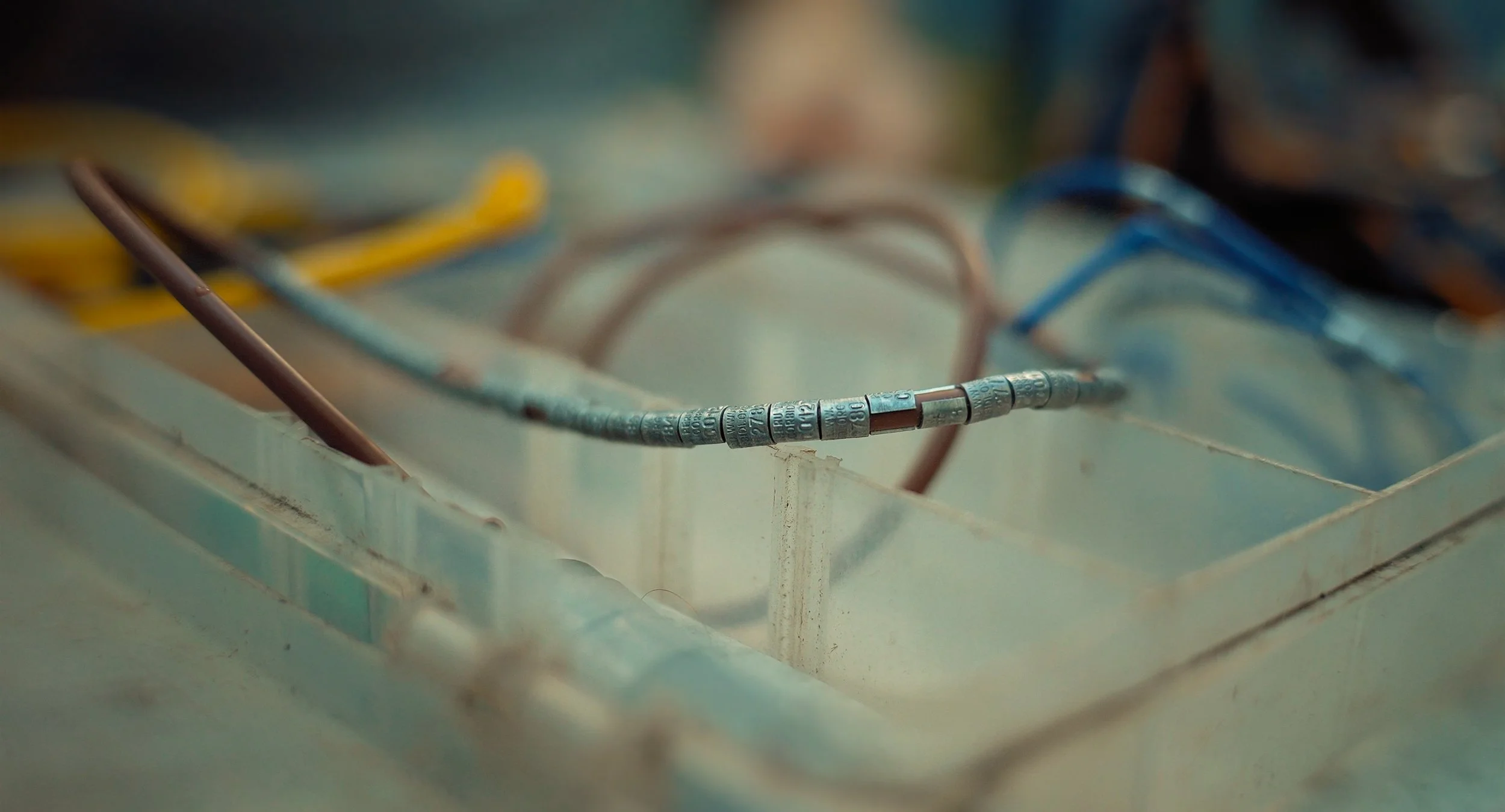 Close-up of bird rings with multiple colored wires connected to a panel in the lowland amazon rainforest in peru by the NGO Fauna Forever