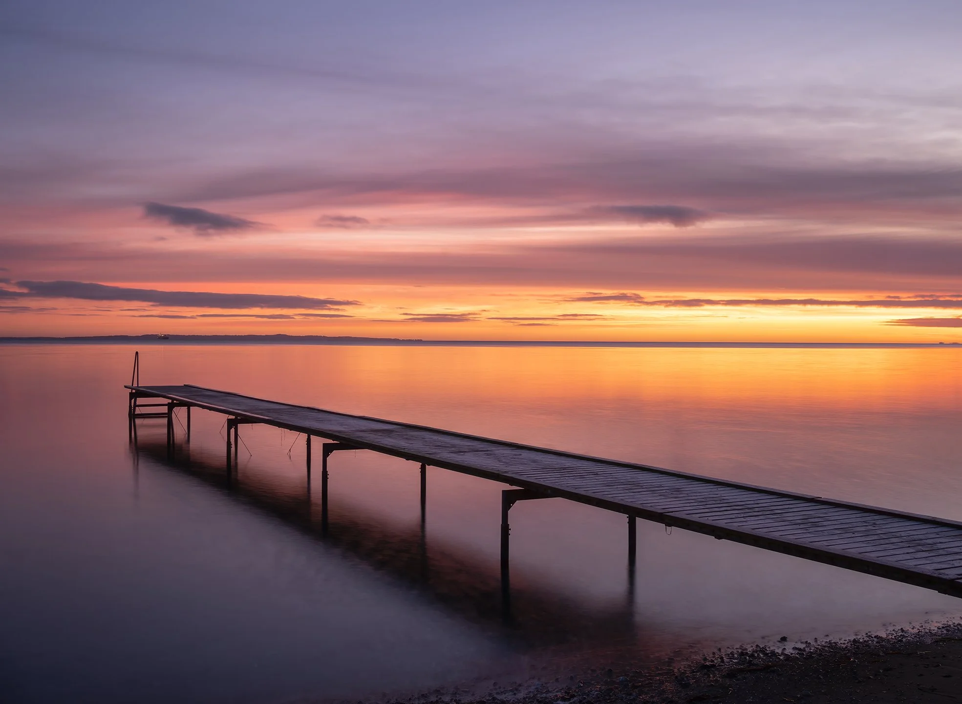 long exposure Photography of a jetty in a warm sunrise