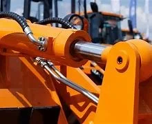 Close-up of a large orange hydraulic arm with metal rods and joints, part of heavy construction equipment.