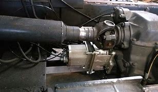 Close-up of a mechanical or industrial machine part, showing a large pipe connected to a metallic component.