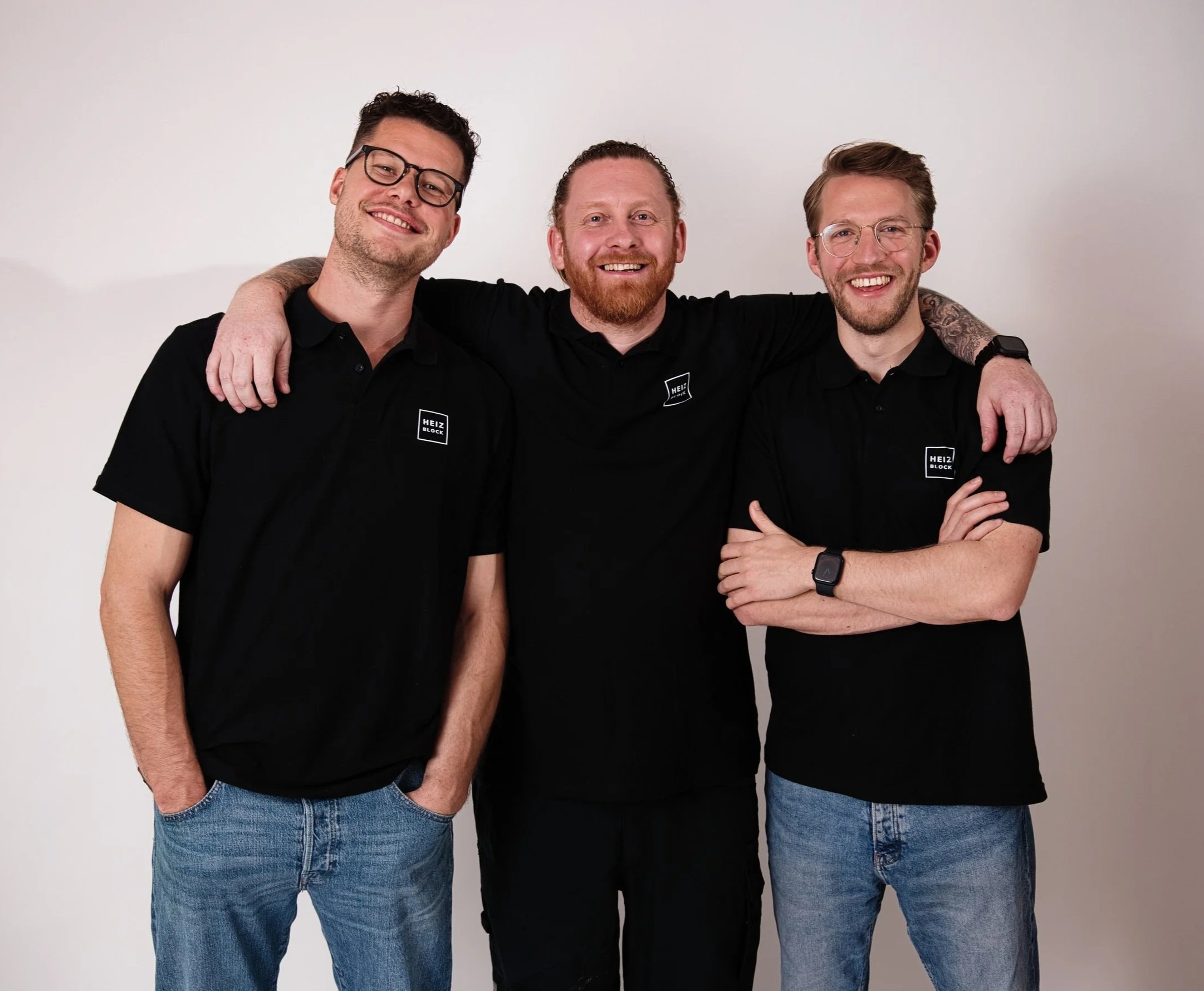 Das Heizblock-Team aus Nürnberg in schwarzen Poloshirts mit Logo vor hellem Hintergrund.