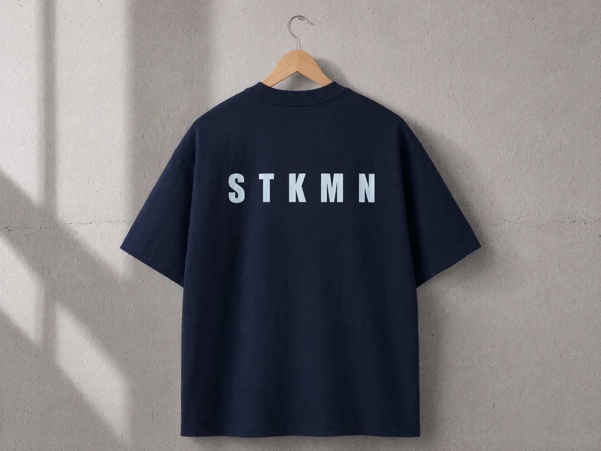 Back view of the STKMN Essential Tee in navy heavyweight organic cotton.